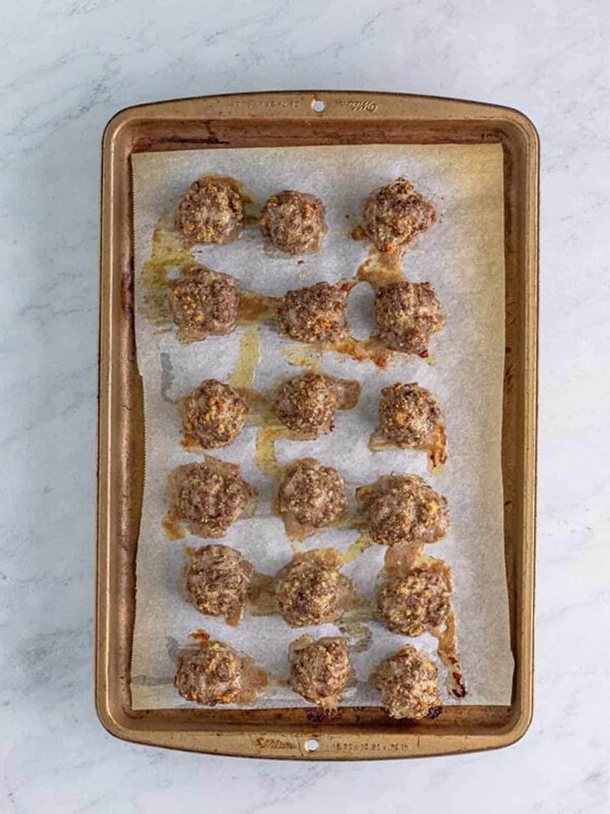Golden baked homemade meatballs on a tray.