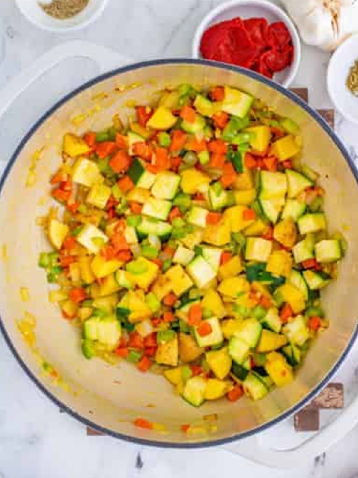 Diced potatoes and zucchini added to the sauteed vegetables for minestrone soup.