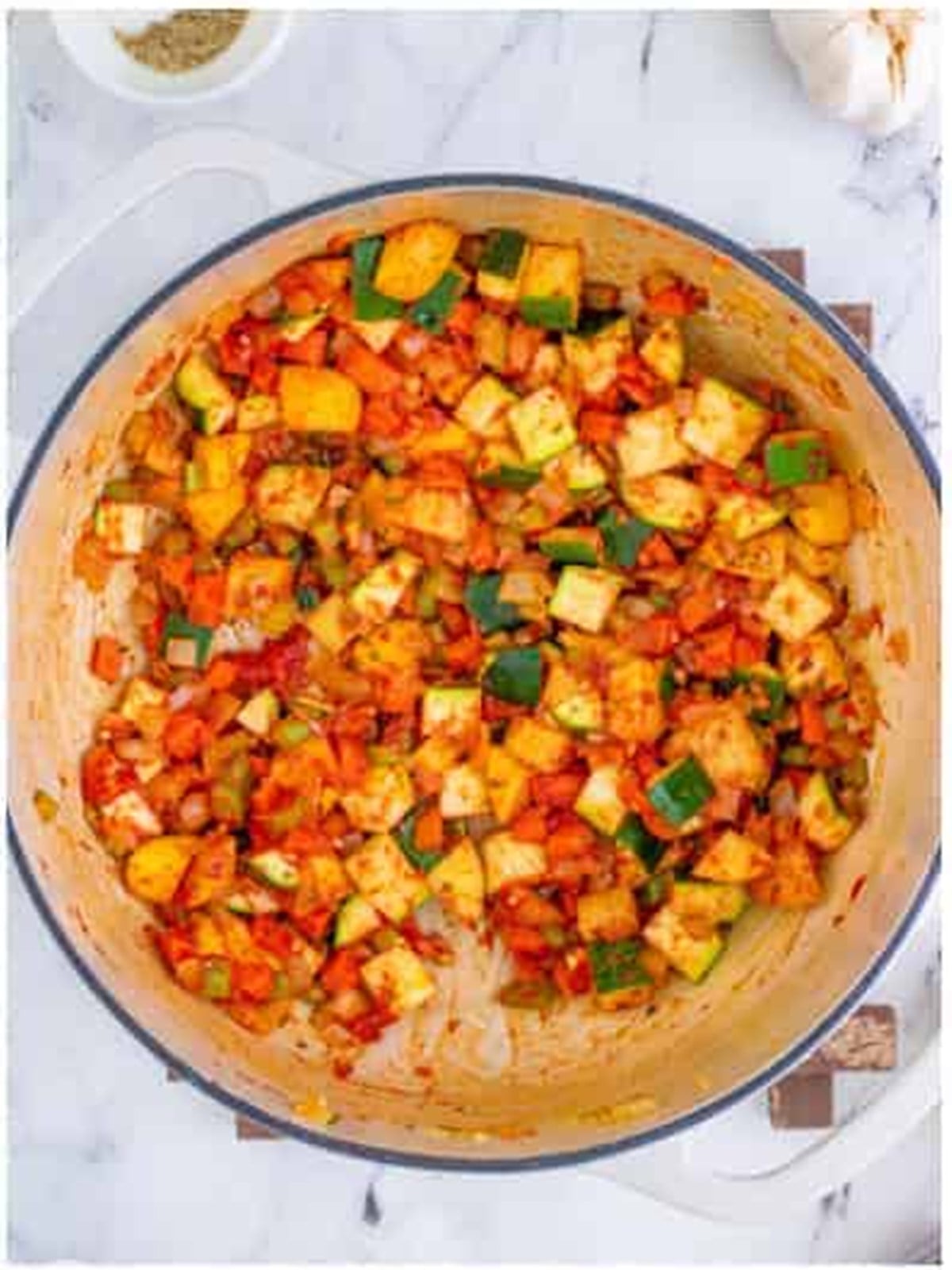 Tomato paste and herbs stirred into the vegetables for minestrone soup.