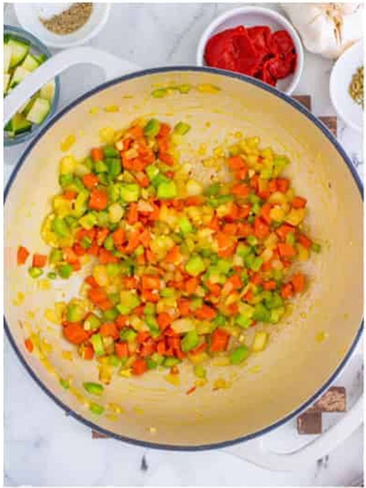 Onion, carrot, and celery sauteed in olive oil in a Dutch oven for minestrone soup.