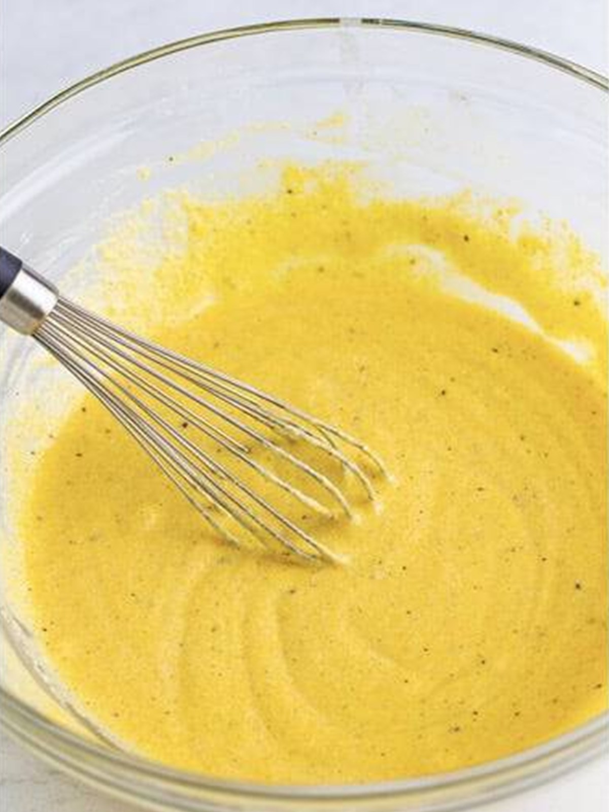The cornmeal corn dog batter whisked smooth in a bowl.