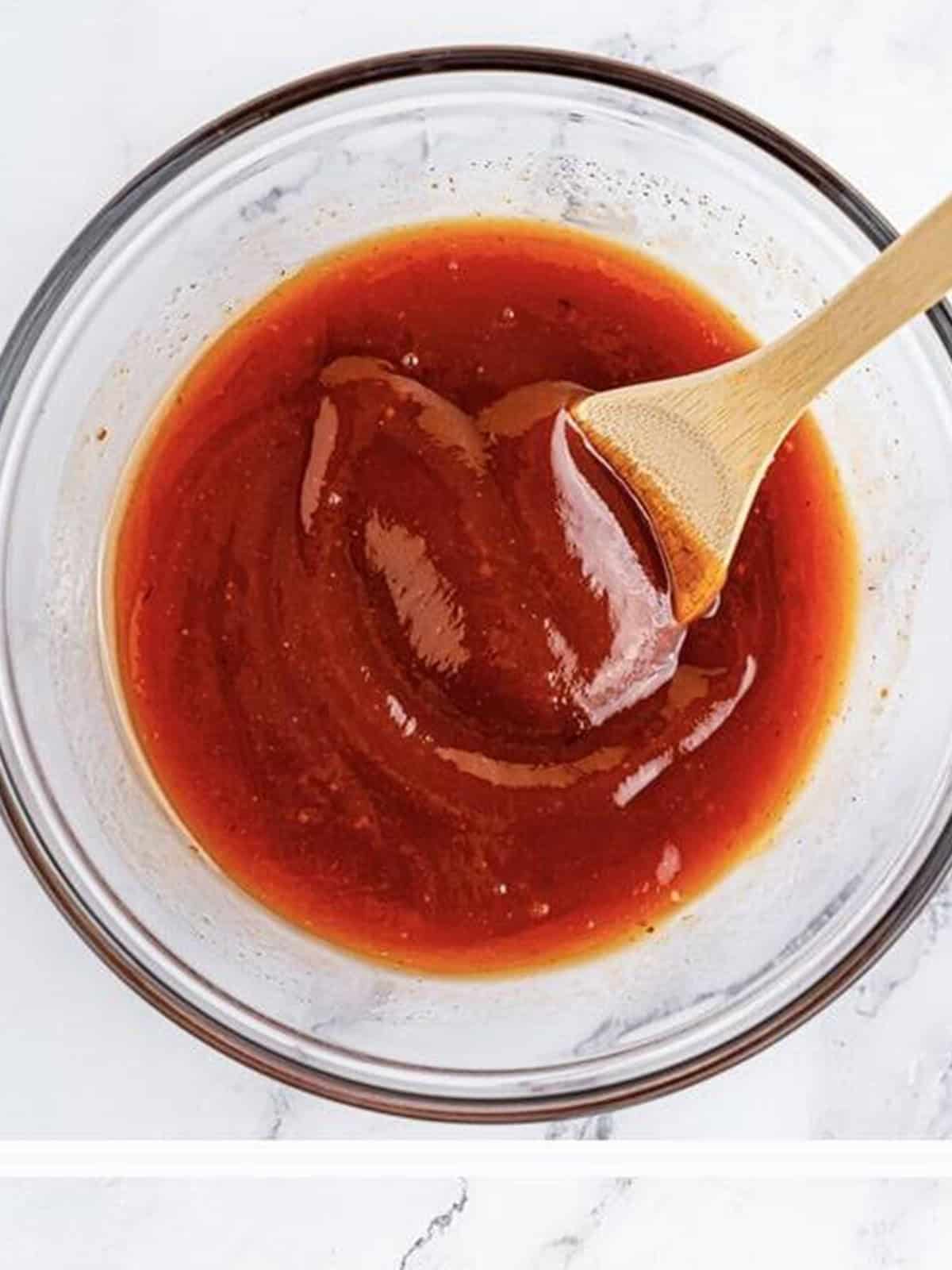 Ketchup and BBQ glaze whisked together in a bowl for mini meatloaf.