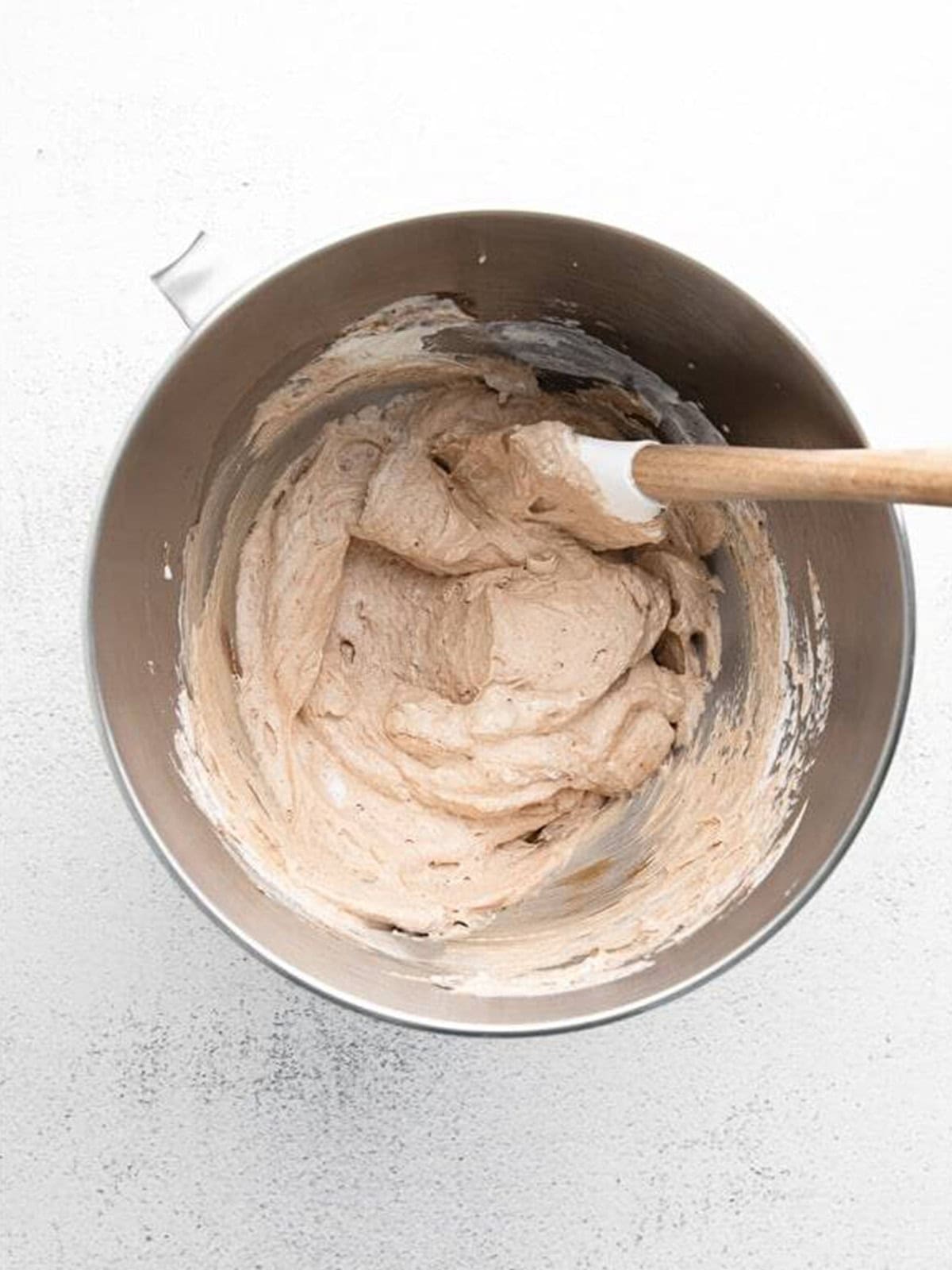 Nutella whipped cream blended in a glass mixing bowl.