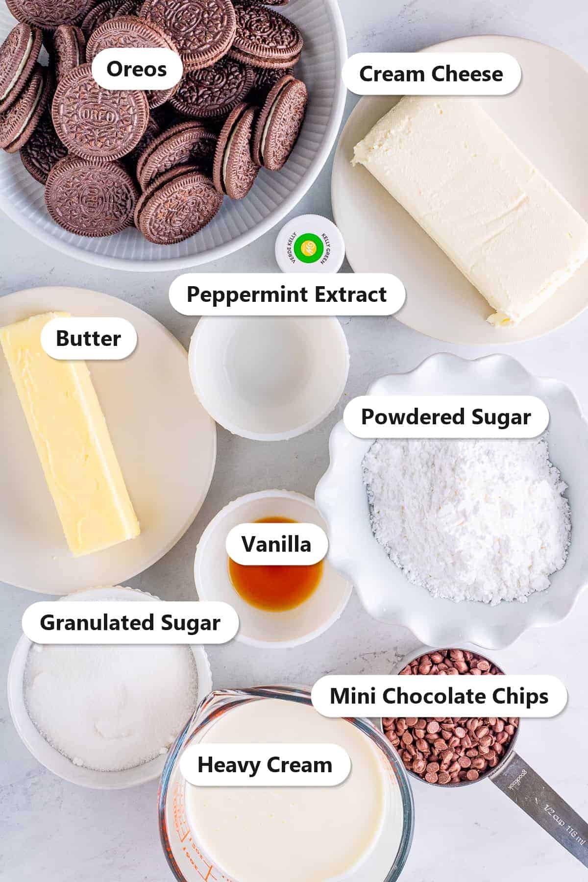 Labeled no bake mint chocolate cheesecake ingredients including Oreos, cream cheese, butter, sugars, peppermint extract, heavy cream, and mini chocolate chips.