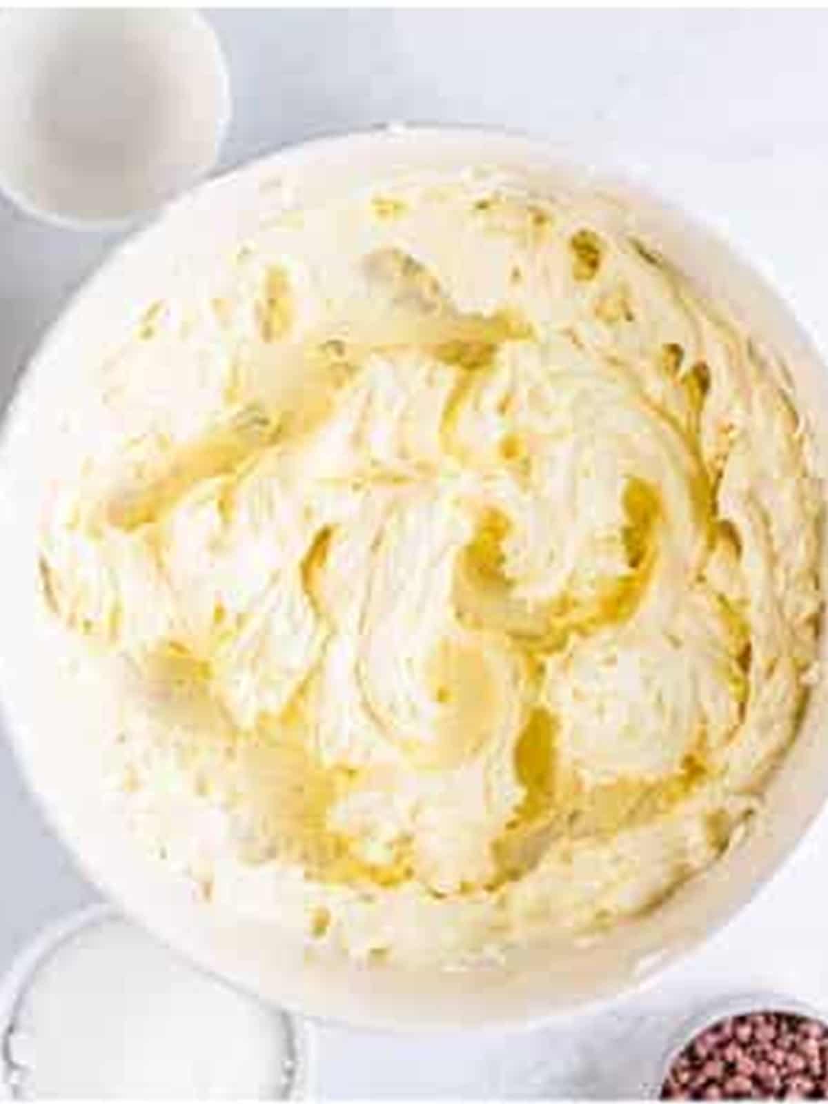 Cream cheese whipped smooth in a bowl for the cheesecake filling.