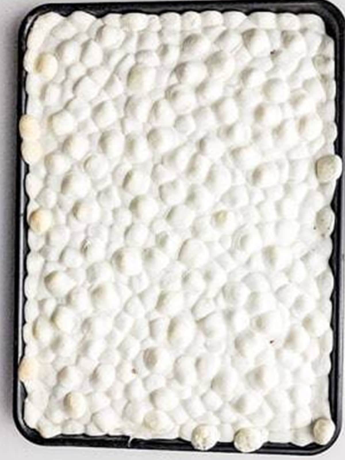 Mini marshmallows spread over the warm baked brownies and puffed in the oven.