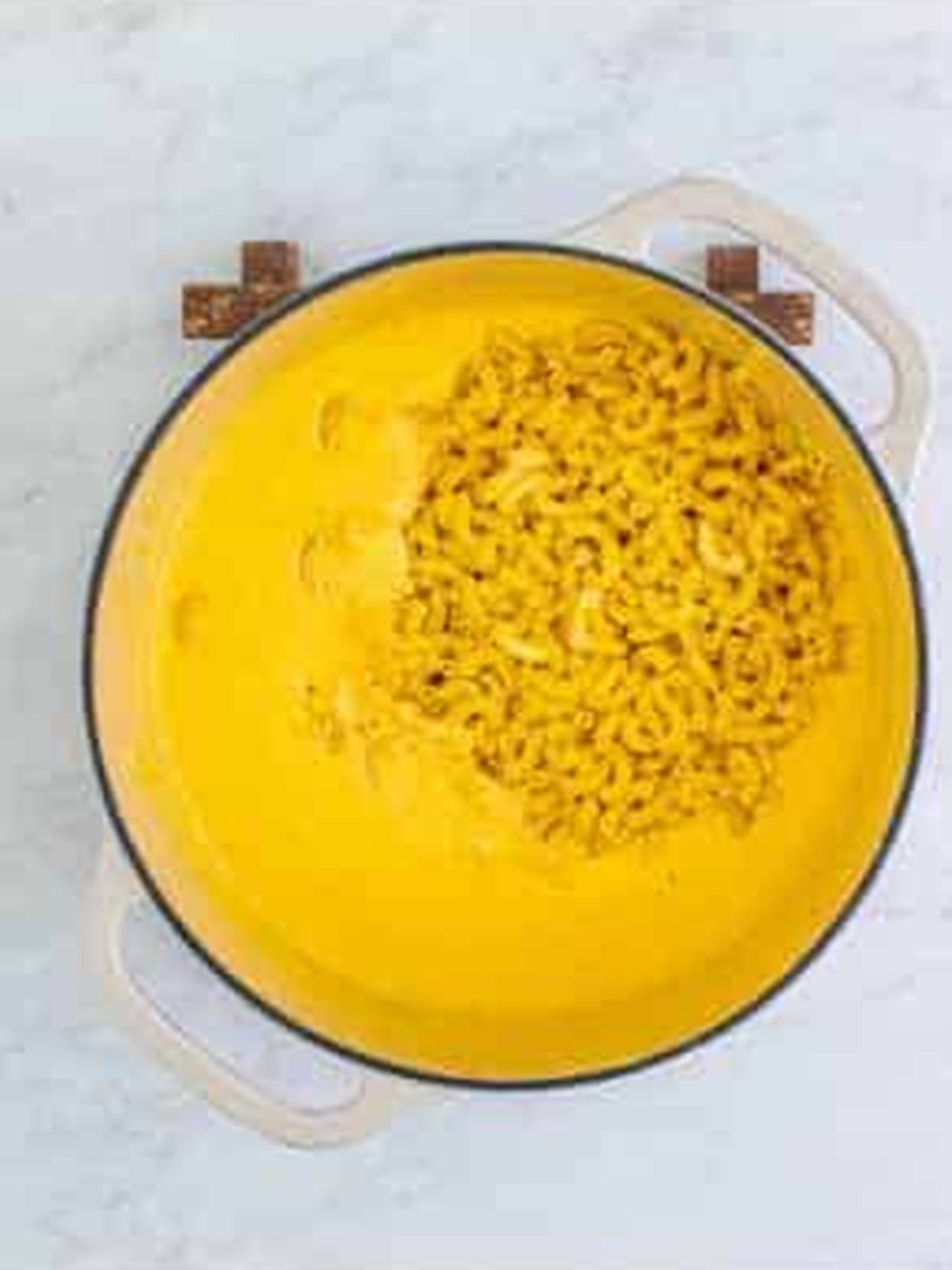 Cooked elbow macaroni added to the cheese sauce.