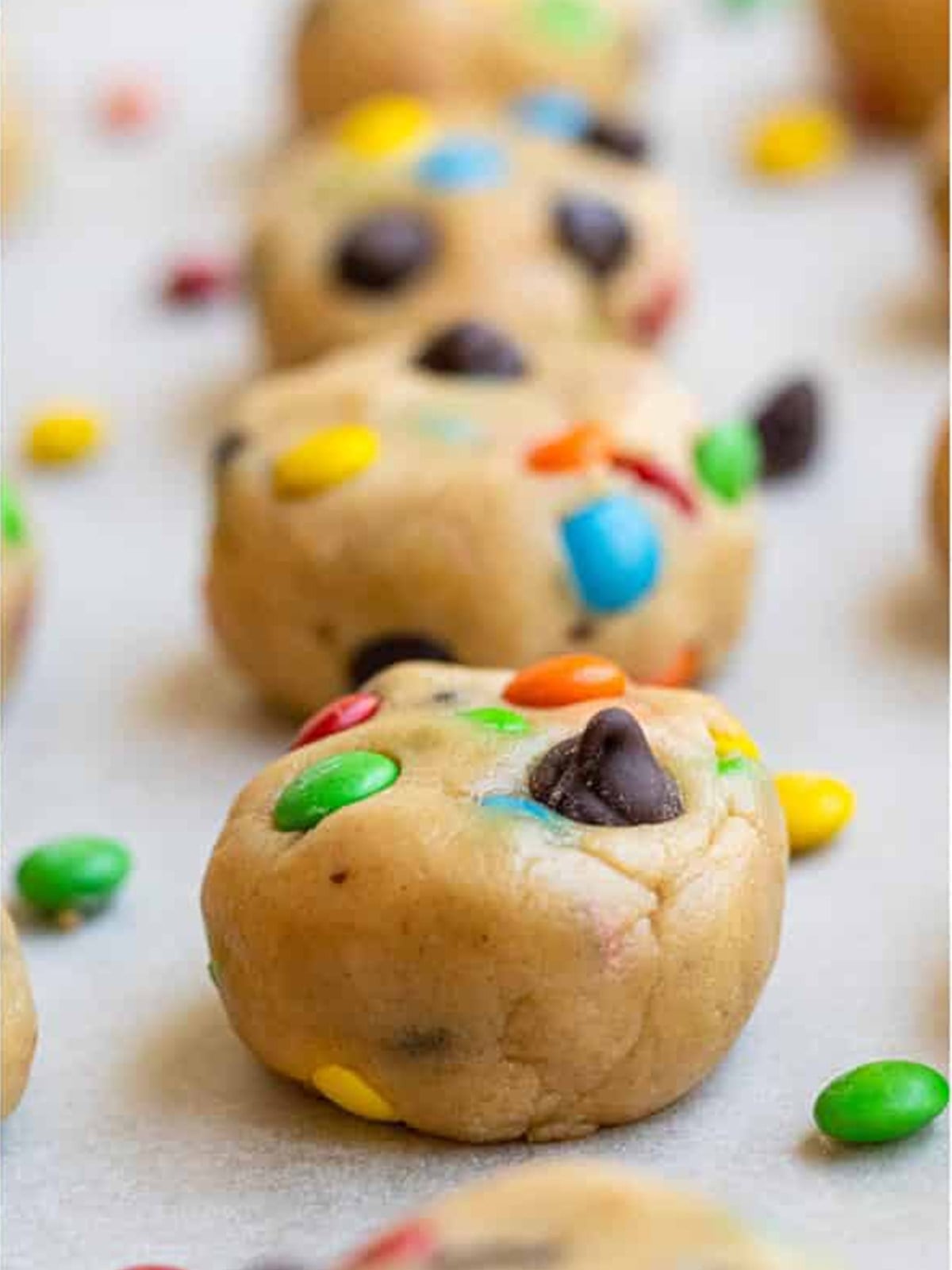 Chilled M and M peanut butter cookie dough balls ready to bake.