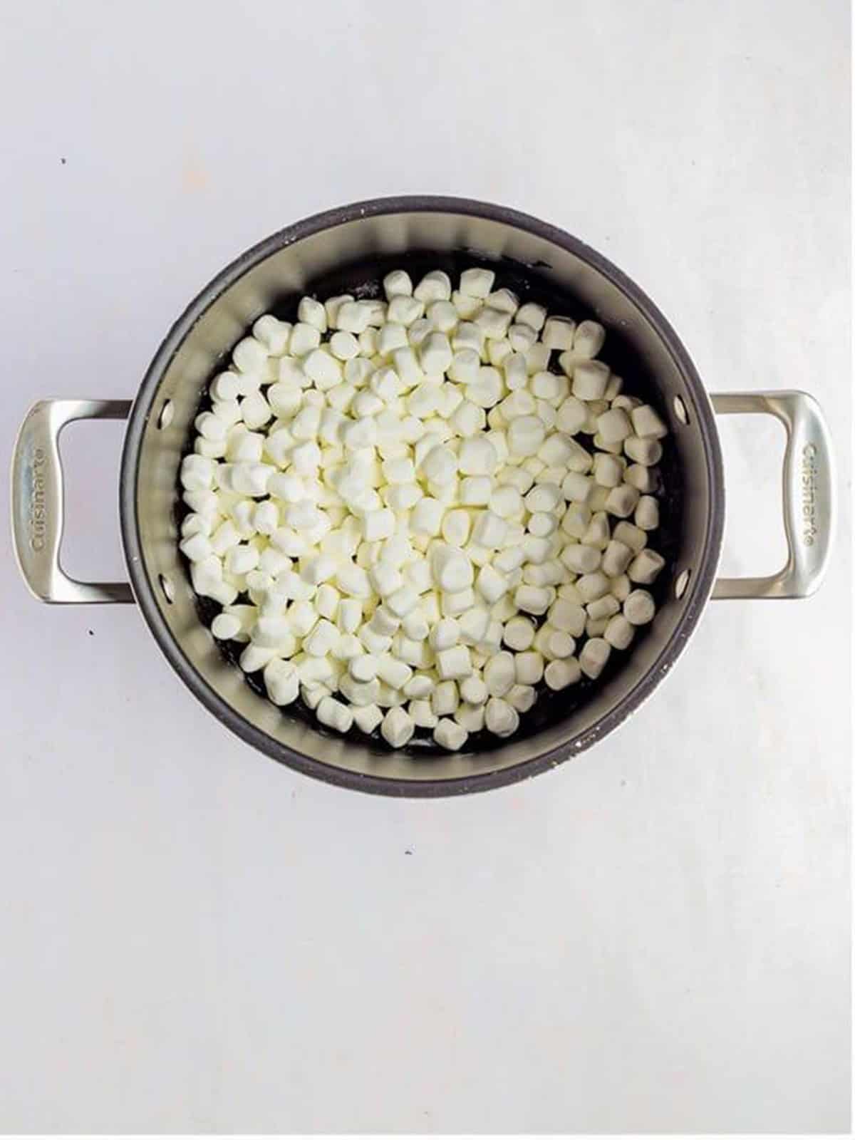 Mini marshmallows and butter melting in a pot for rice krispie treats.