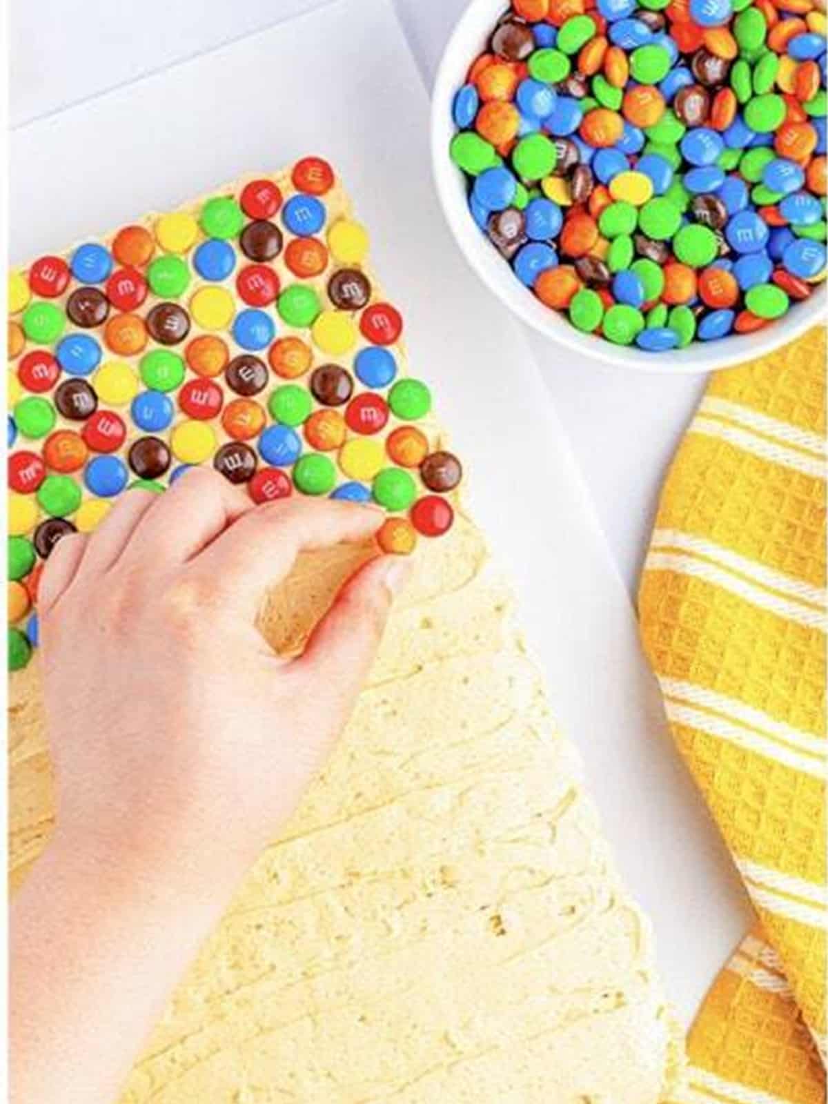 M&M candies pressed into the peanut butter frosting on rice krispie treats.