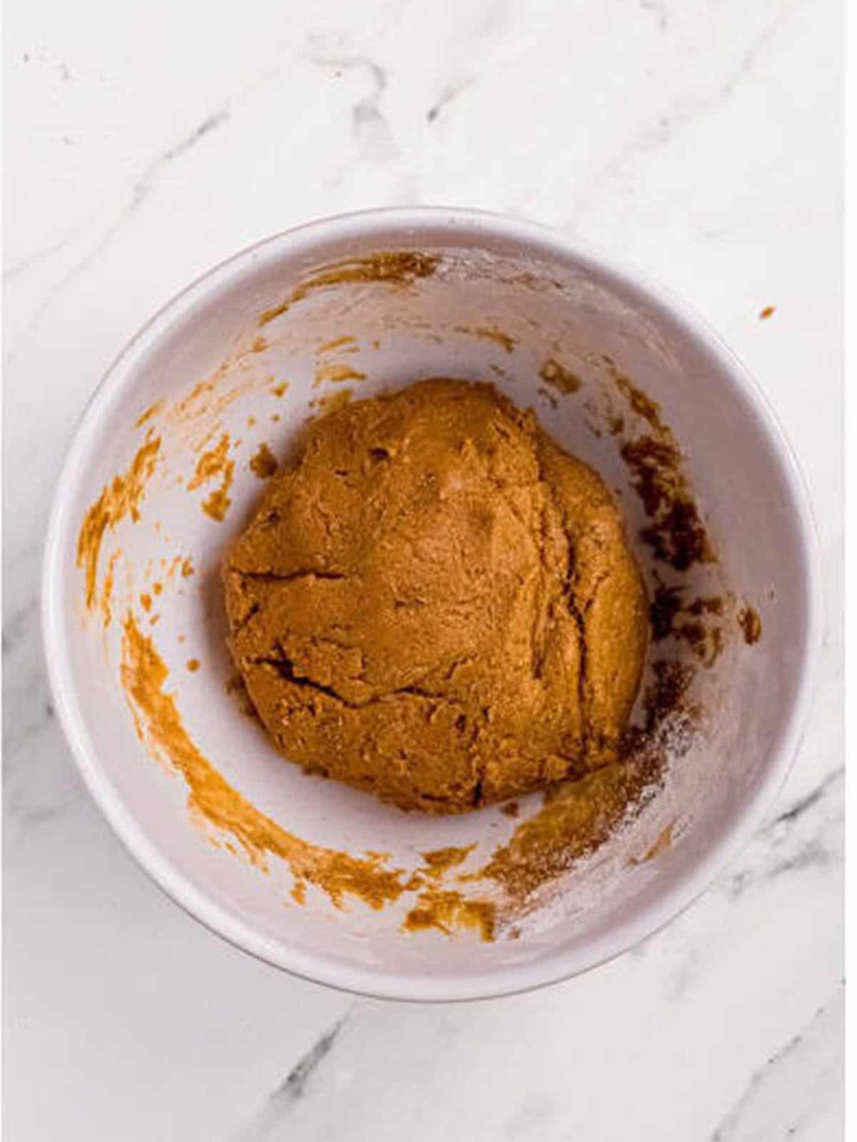 Soft molasses cookie dough mixed in a bowl.