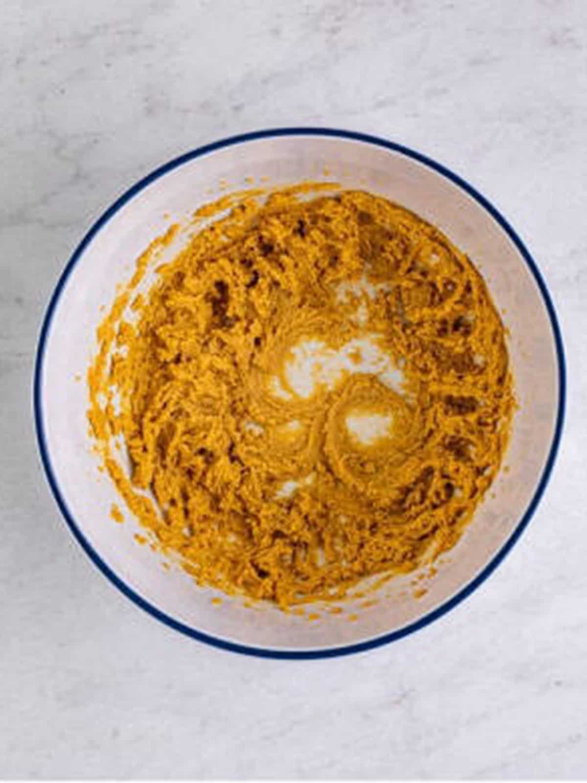 Brown sugar, butter, and peanut butter creamed together in a white bowl.
