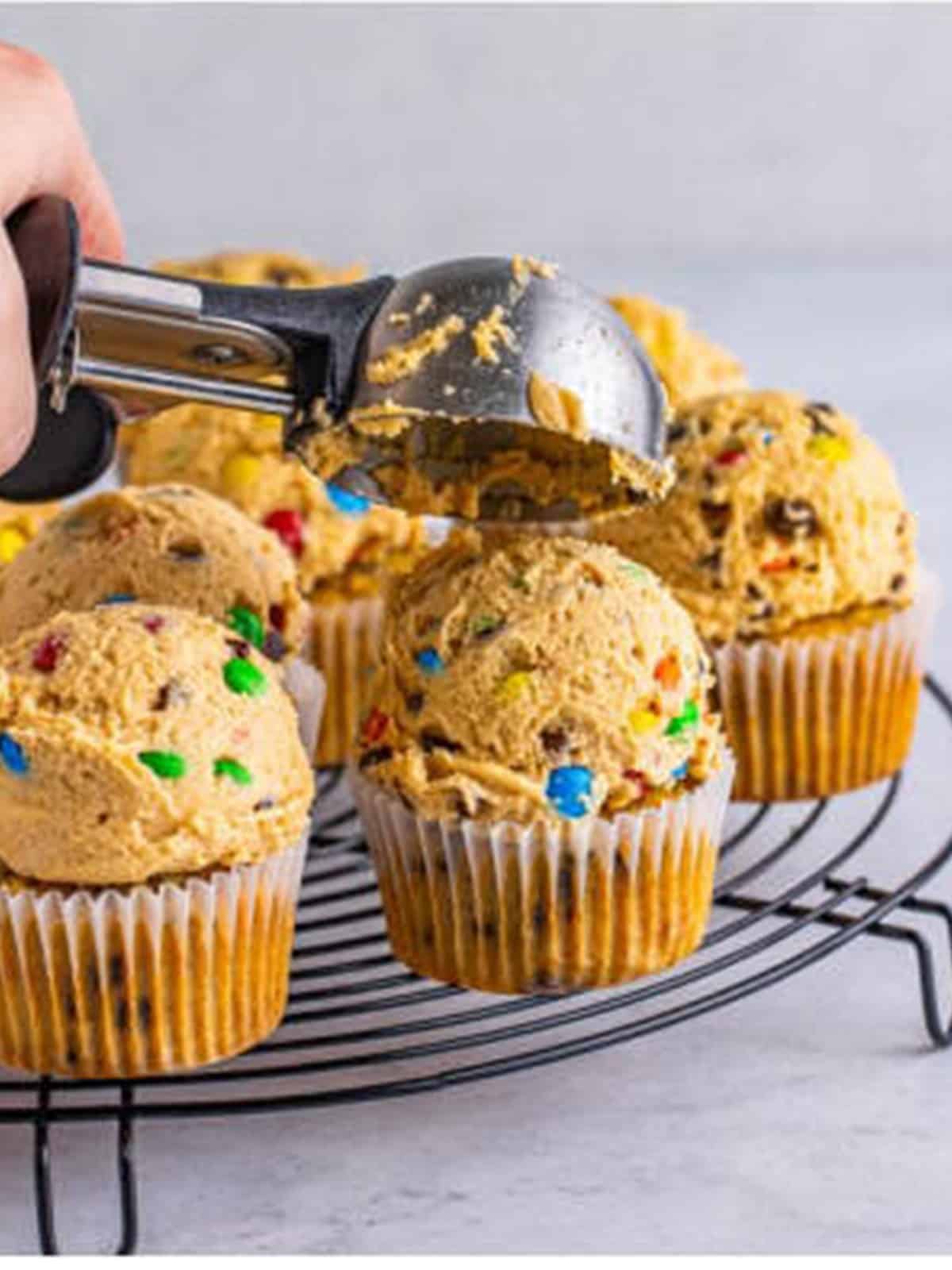 Peanut butter frosting with mini chocolate chips and M&Ms scooped onto the baked cupcakes.