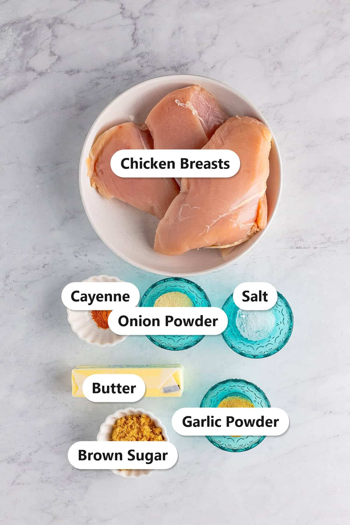 Labeled ingredients for slow cooker Nashville hot chicken sandwiches including chicken breasts, cayenne, brown sugar, butter, and spices.
