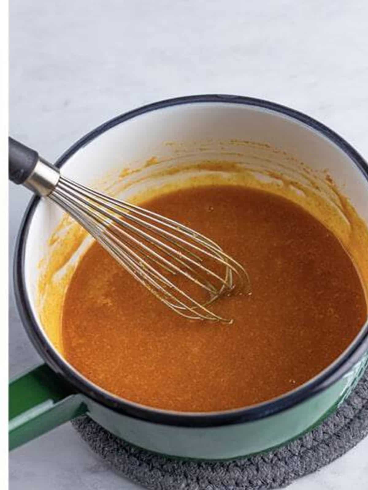 Spicy Nashville hot sauce whisked together in a saucepan.