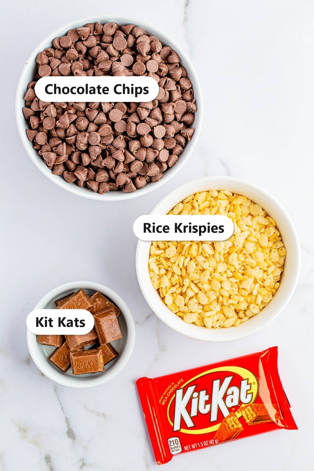 Labeled ingredients for Nestle crunch bars: chocolate chips, rice krispies cereal, and chopped Kit Kats.