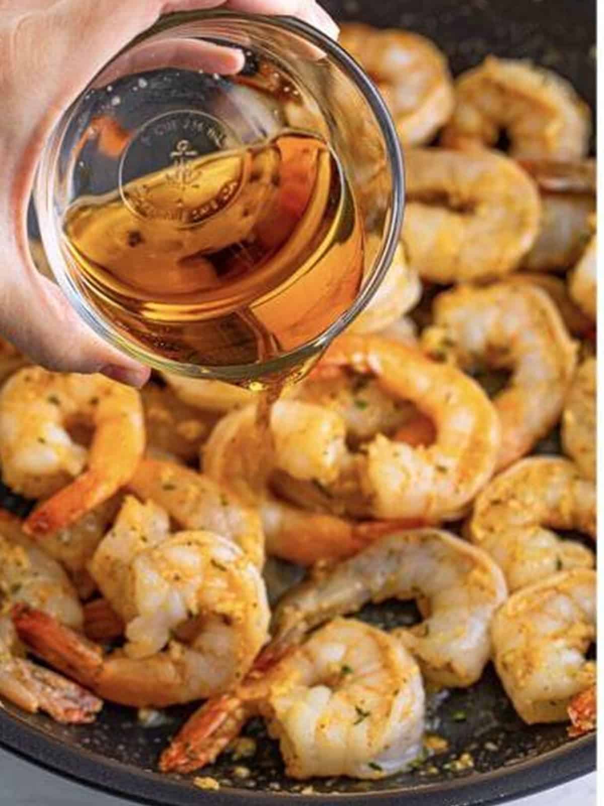 Lager beer poured into the skillet to deglaze the pan of shrimp.