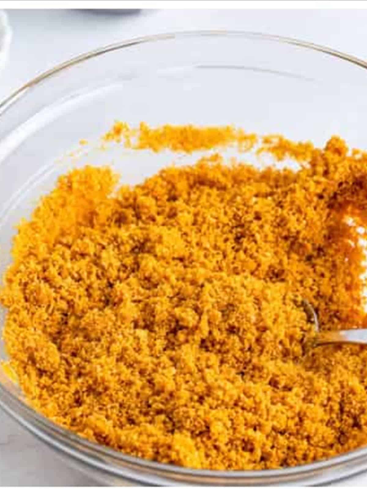 Mixing graham cracker crumbs, butter, and sugar for no bake cheesecake recipe crust.
