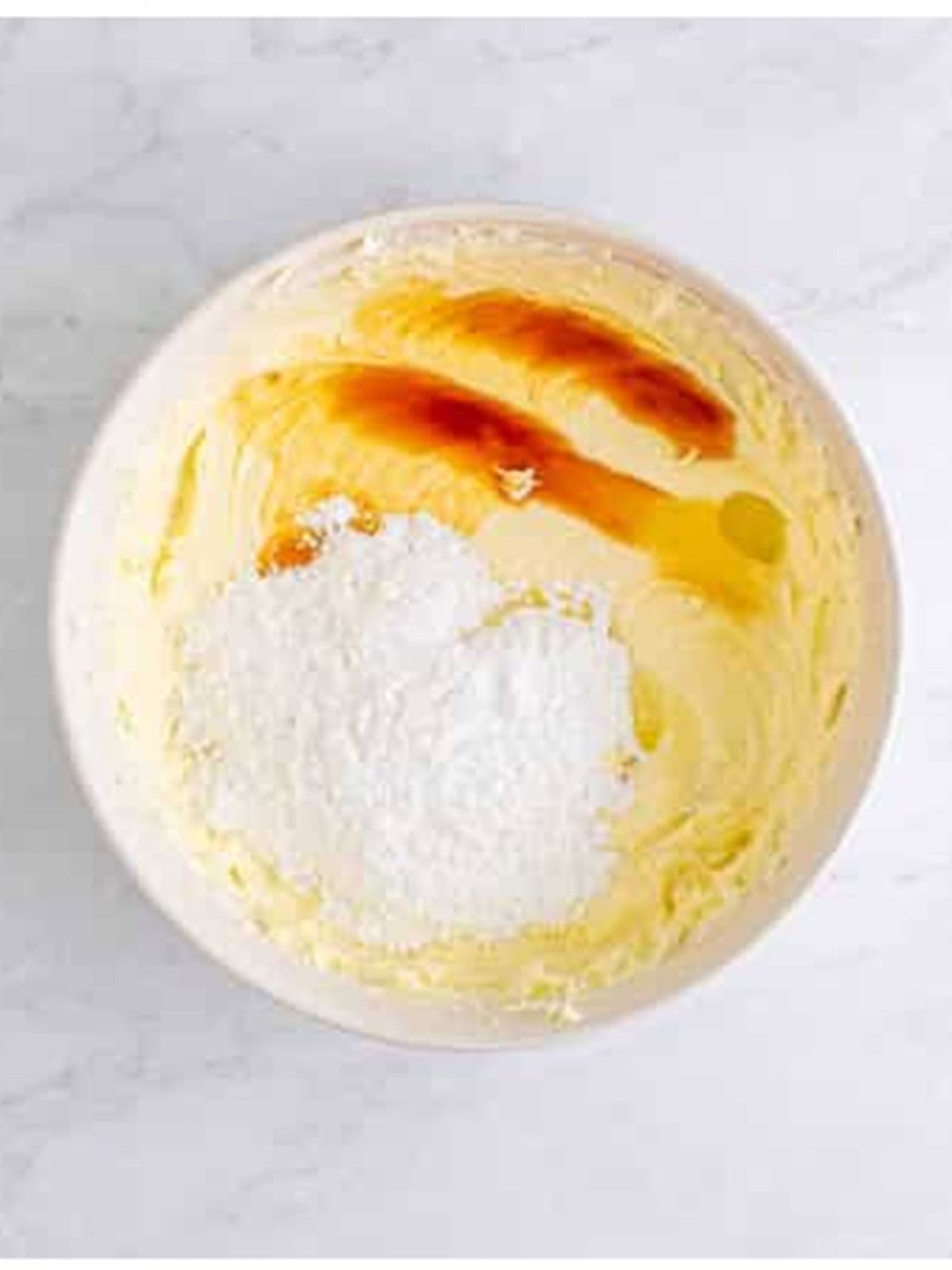 Adding powdered sugar, vanilla, and lemon juice for no bake cheesecake recipe.