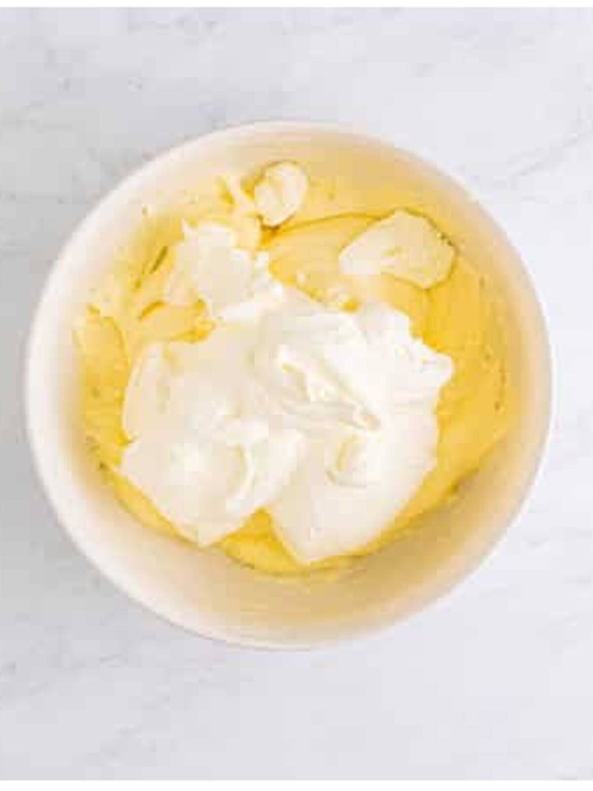 Folding whipped cream into the cream cheese for no bake cheesecake recipe.