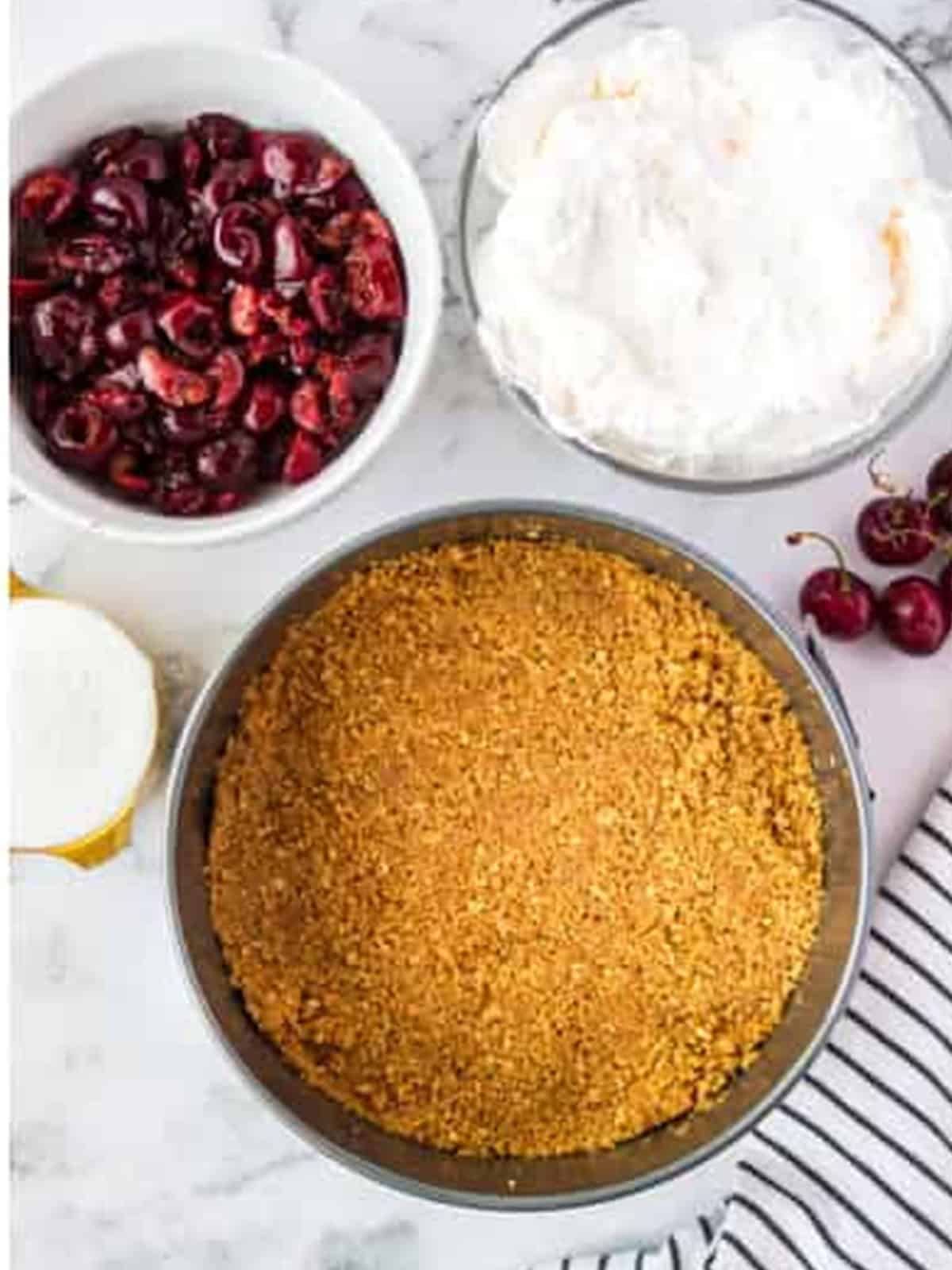 Graham cracker crust pressed into a springform pan for no bake cherry cheesecake.