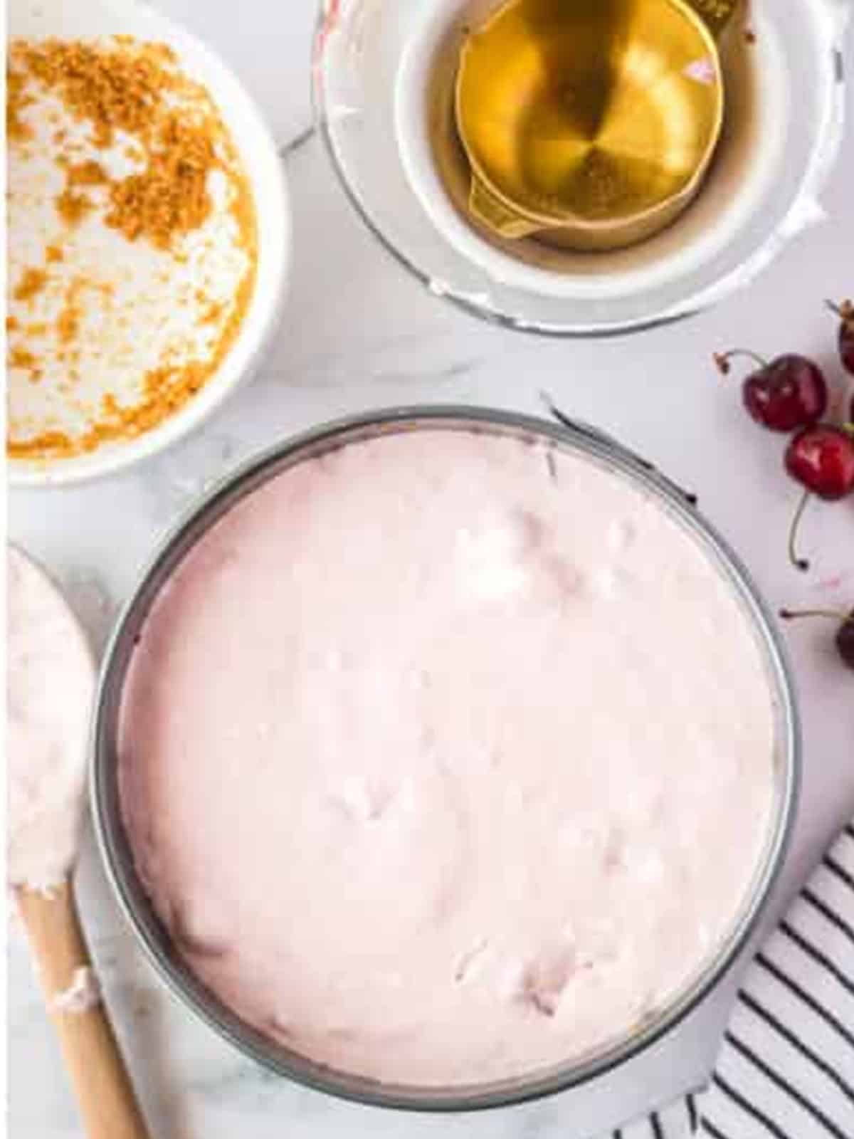 Smoothed no bake cherry cheesecake filling in a springform pan.