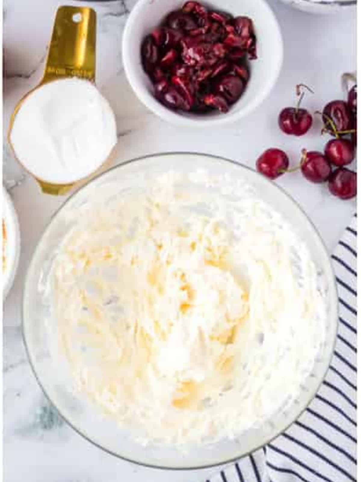 Cream cheese whipped smooth in a glass bowl.