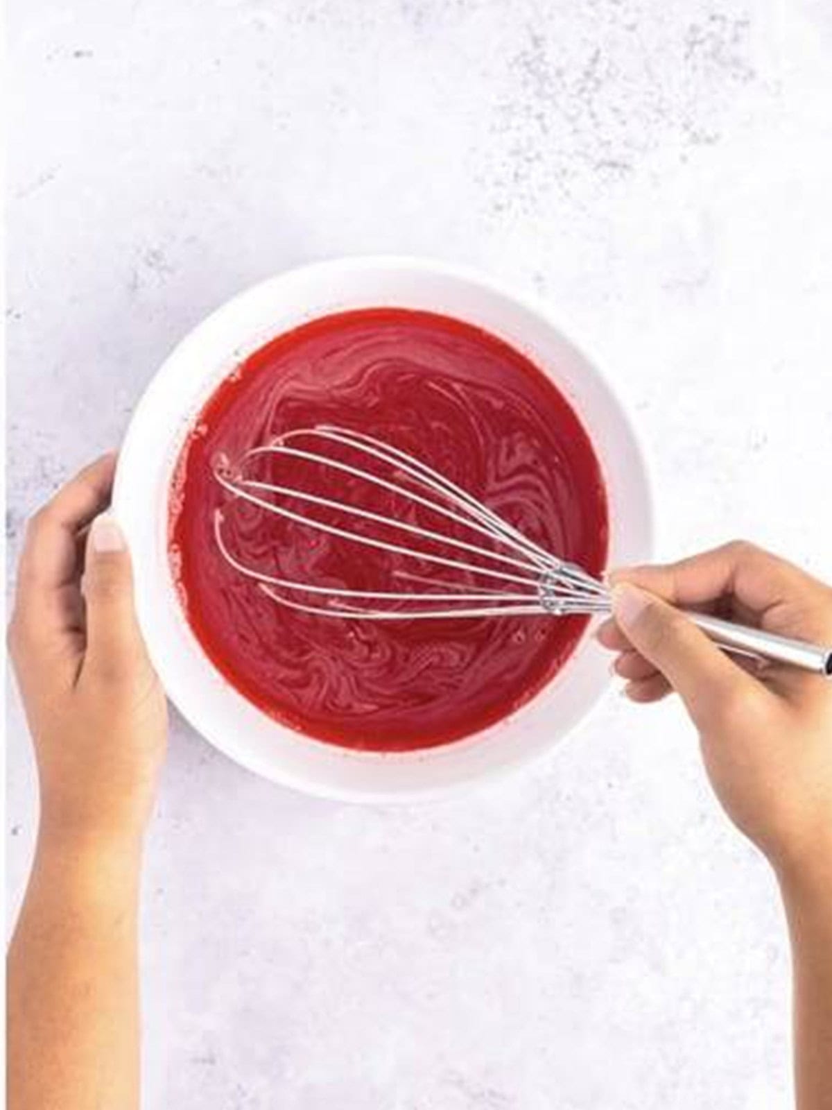 Whisking the Jell-O into the hot water until fully dissolved.