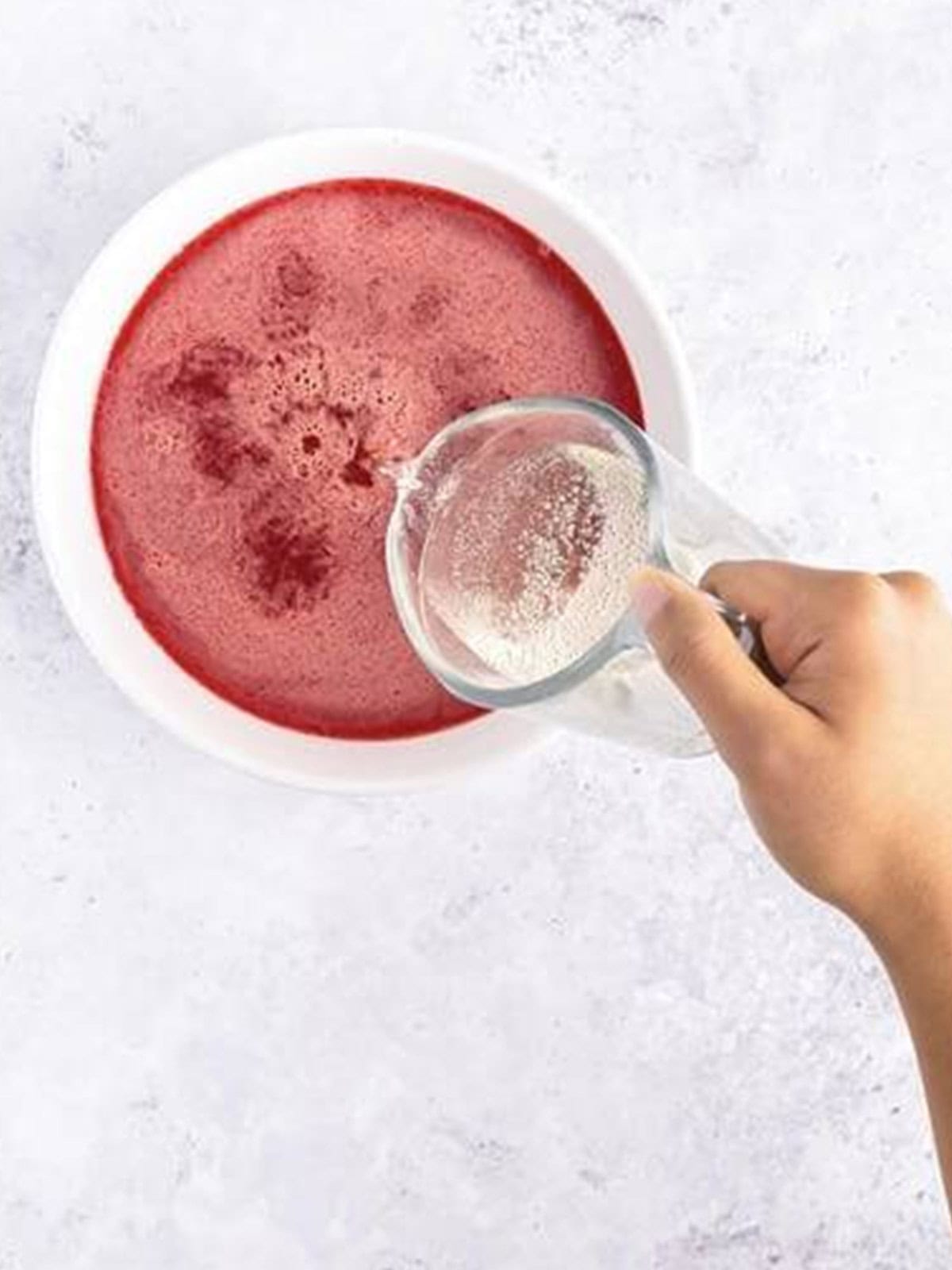 Pouring chilled sparkling grape juice into the dissolved Jell-O.