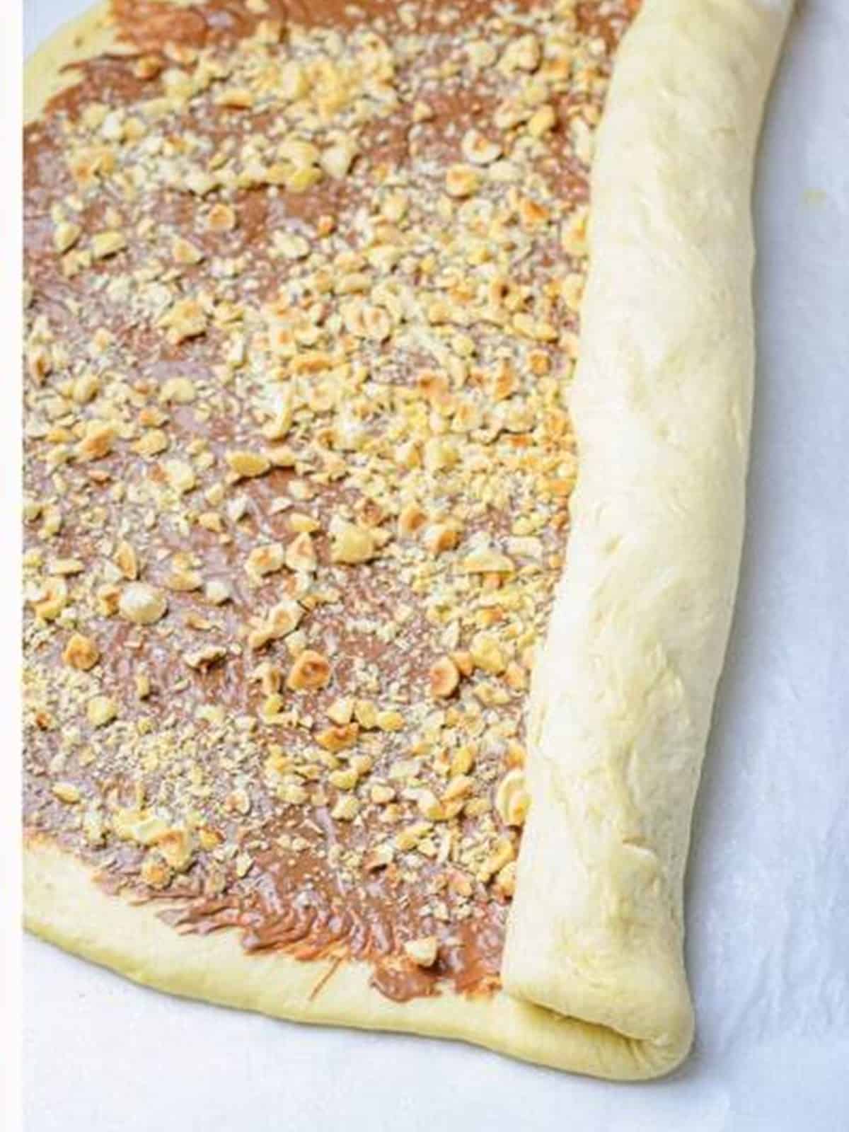 Nutella covered dough rolled up tightly into a long log.