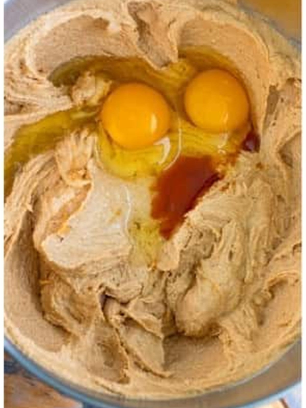 Adding eggs and vanilla to the peanut butter cookie dough.