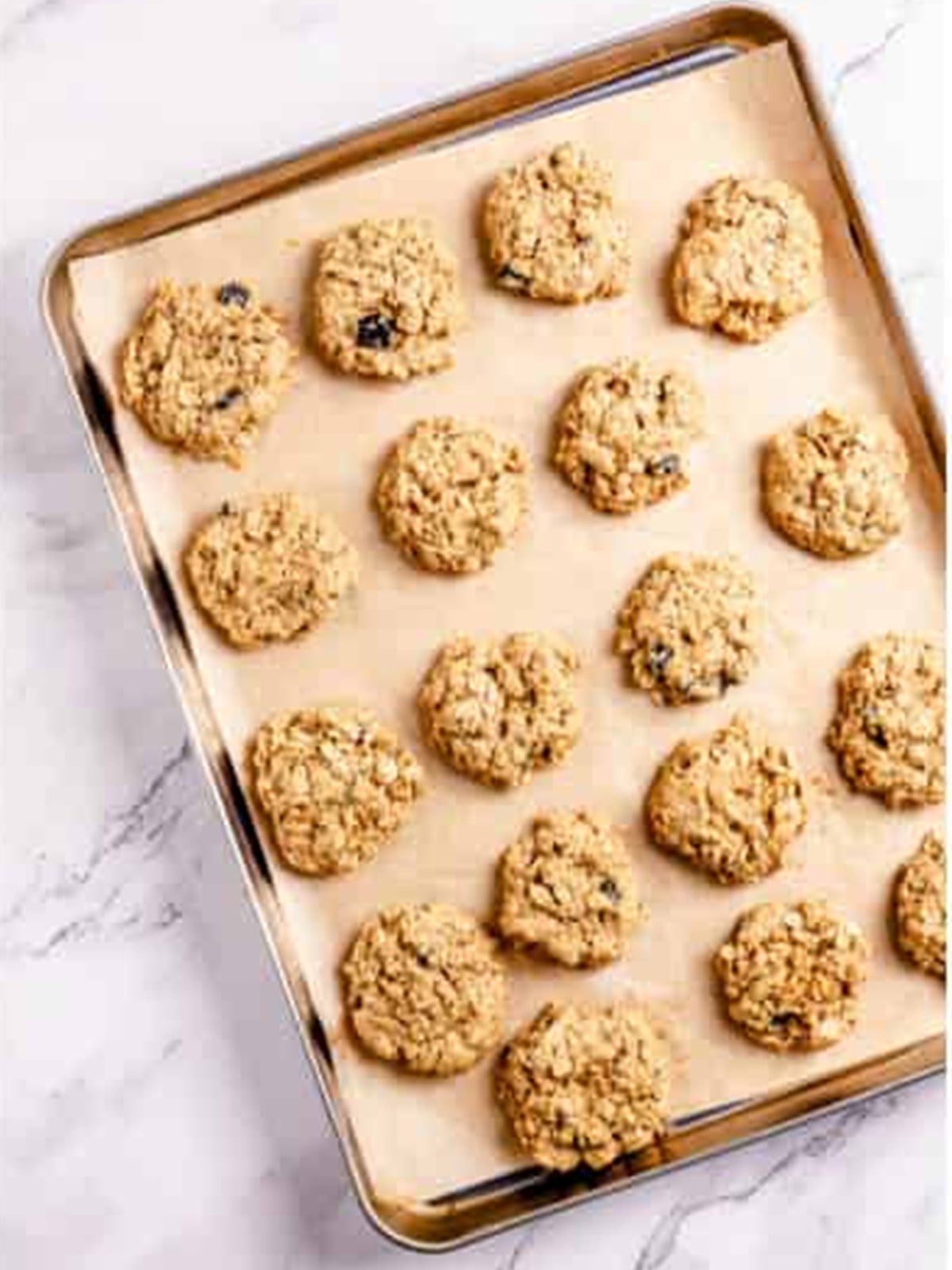 Rows of oatmeal blueberry cookie dough balls ready to bake.