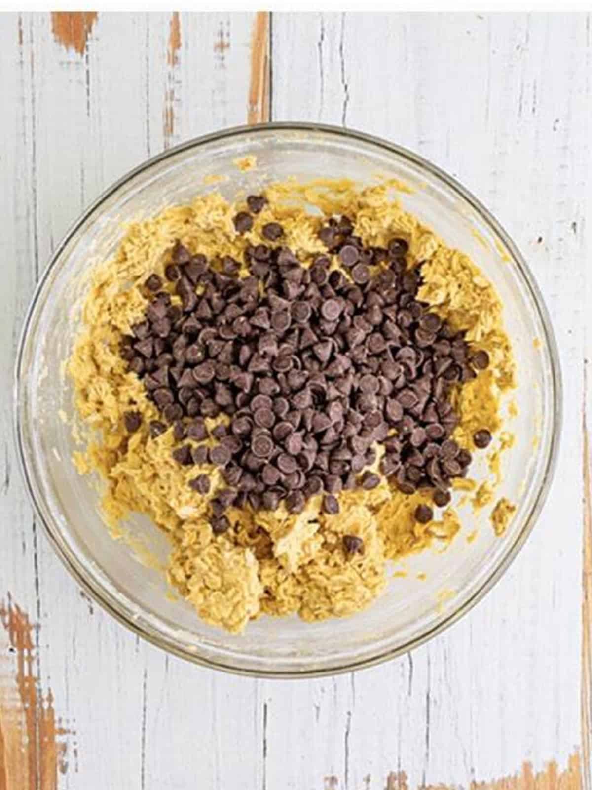 Stirring chocolate chips into the oatmeal cookie bar dough.