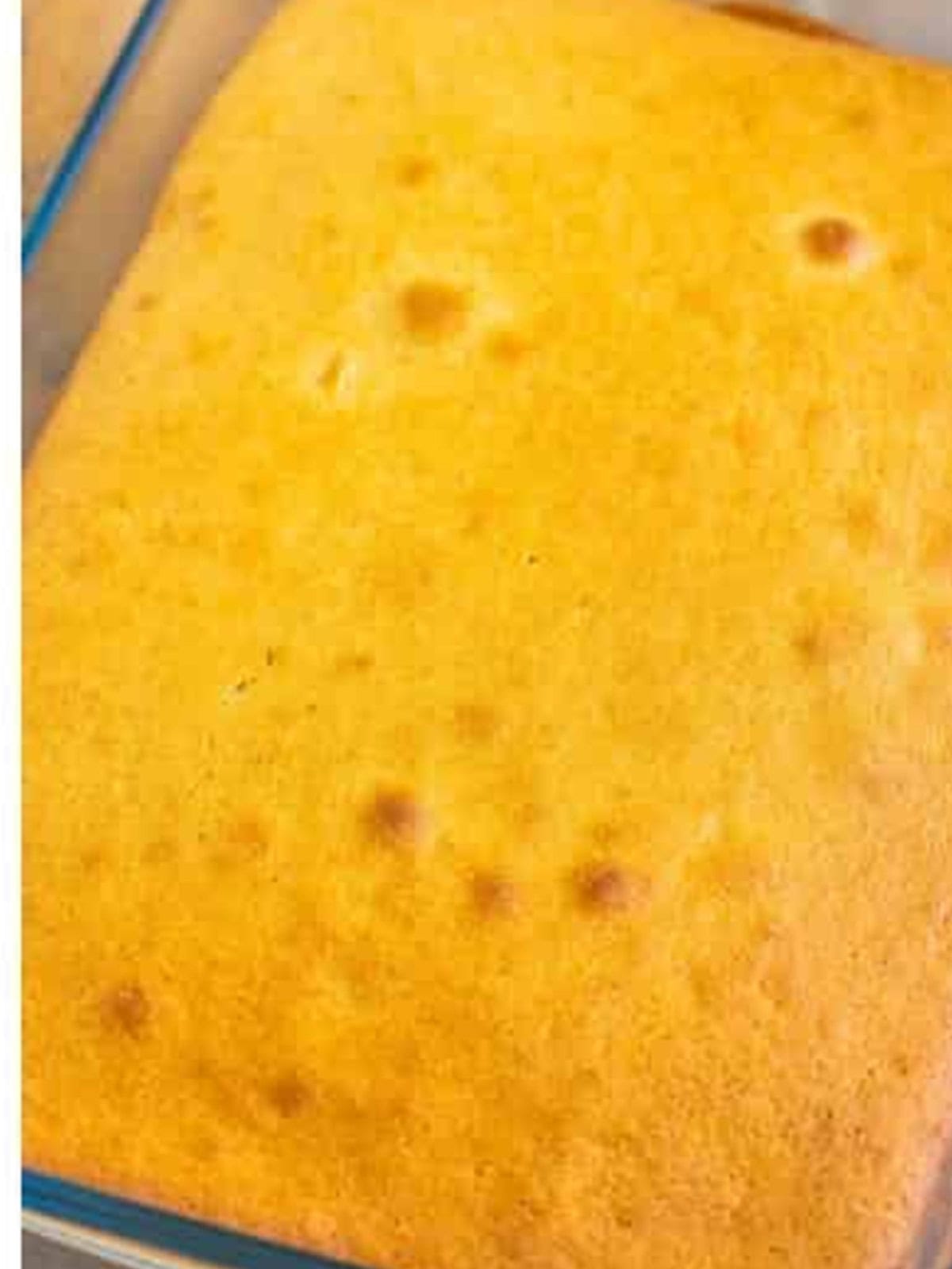 Golden baked vanilla cake in a glass baking dish.
