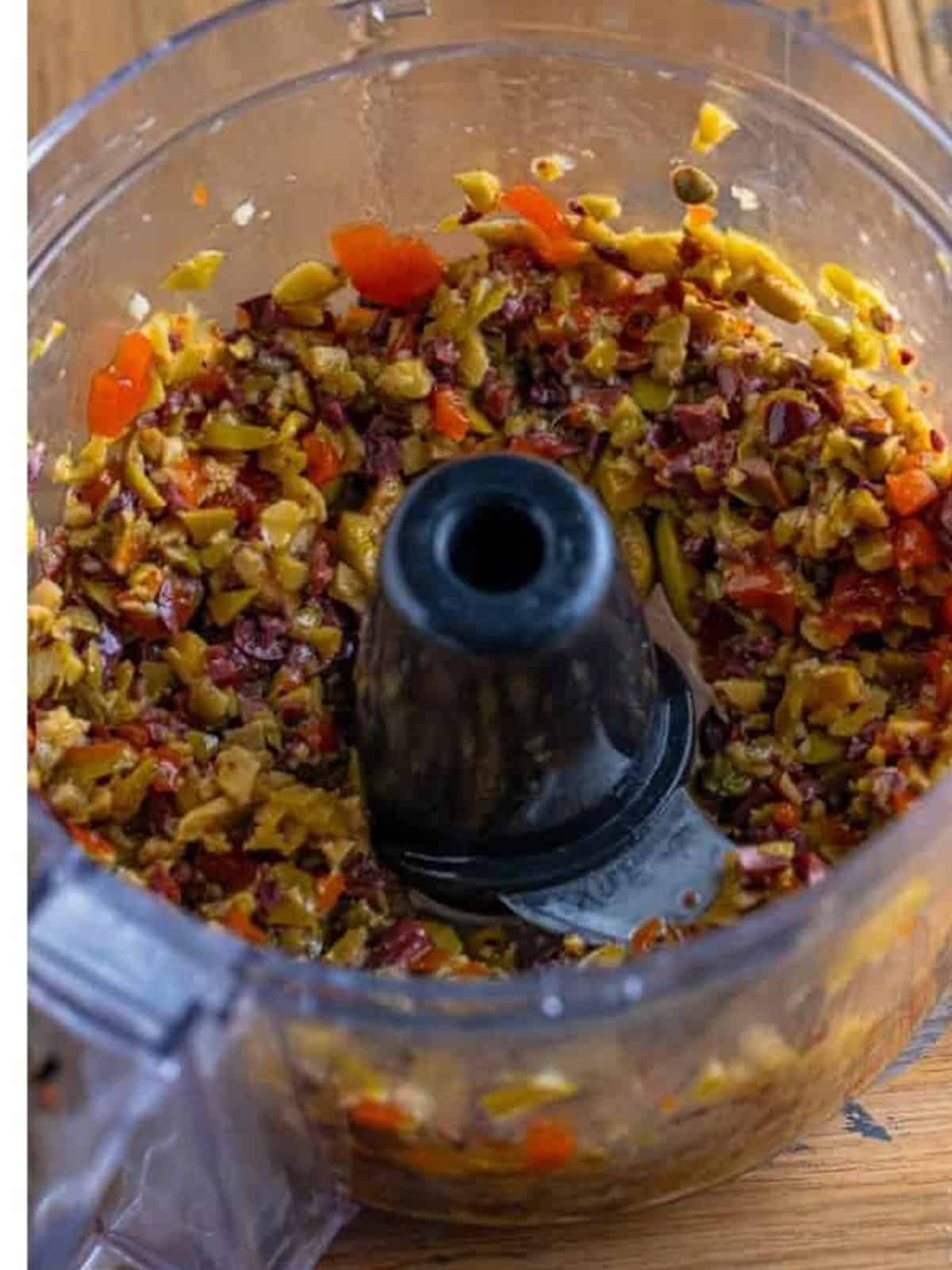 Olives pulsed into a coarse chop in the food processor for olive tapenade recipe.