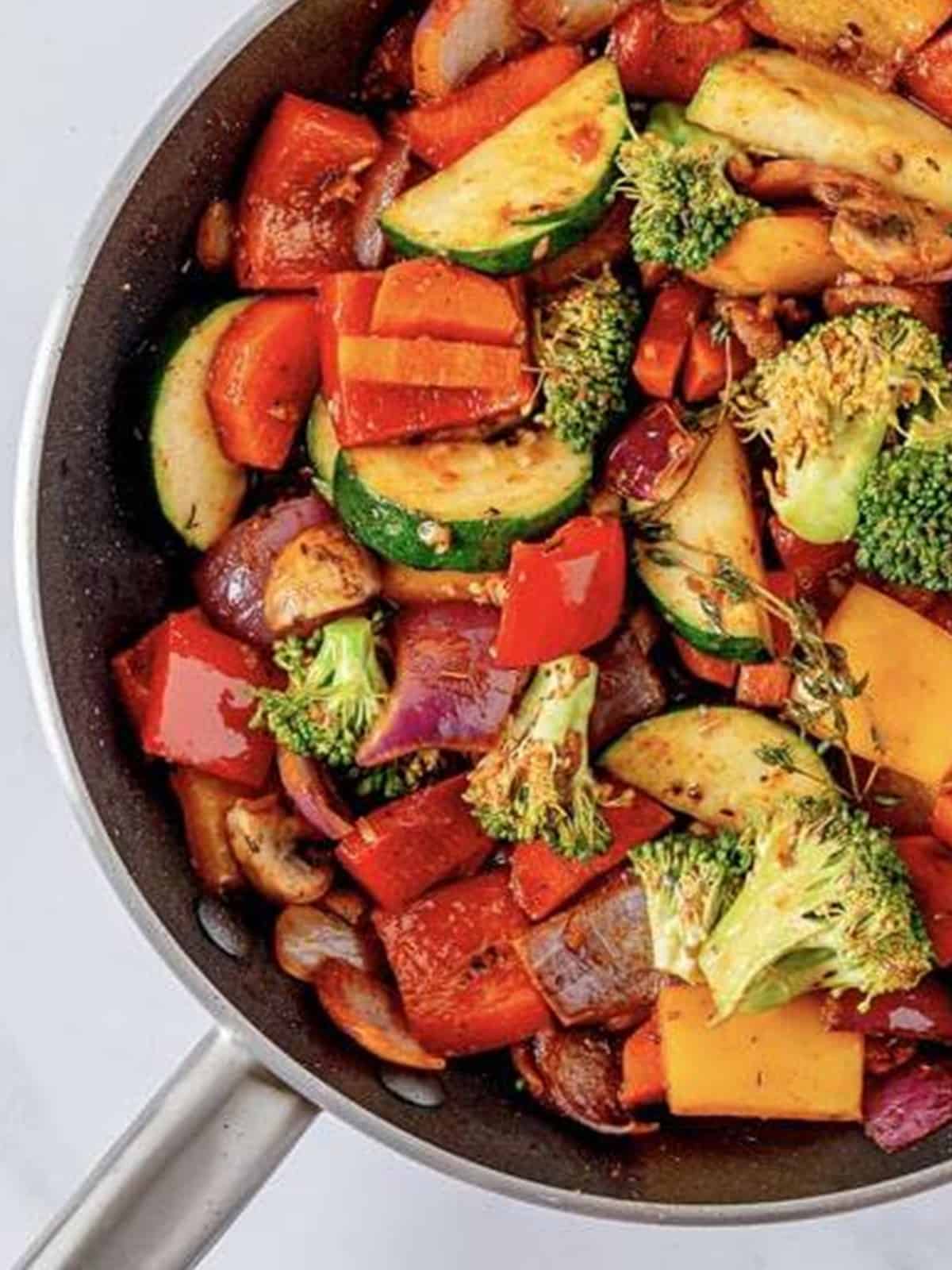 Zucchini, carrots, mushrooms, and broccoli added to the skillet of vegetables.