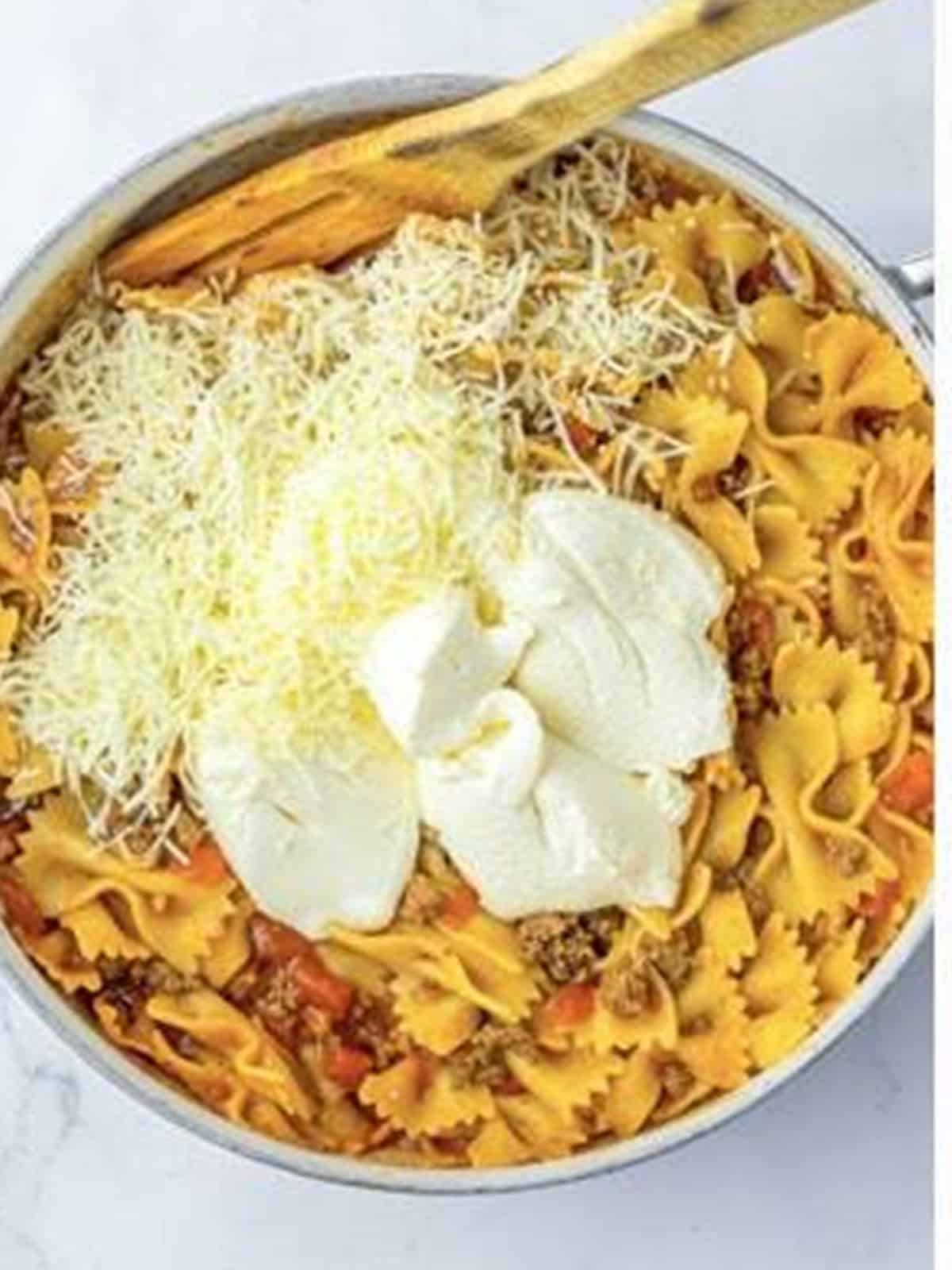 Ricotta and mozzarella stirred into one pot lasagna in a skillet.