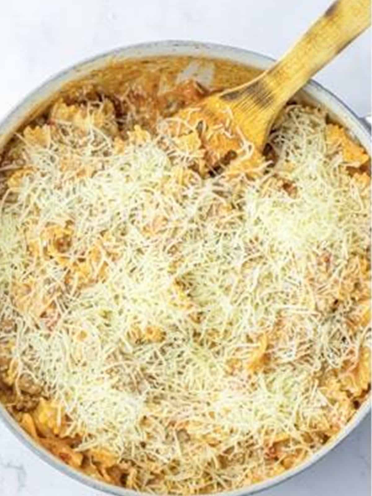 One pot lasagna topped with shredded mozzarella in a skillet.