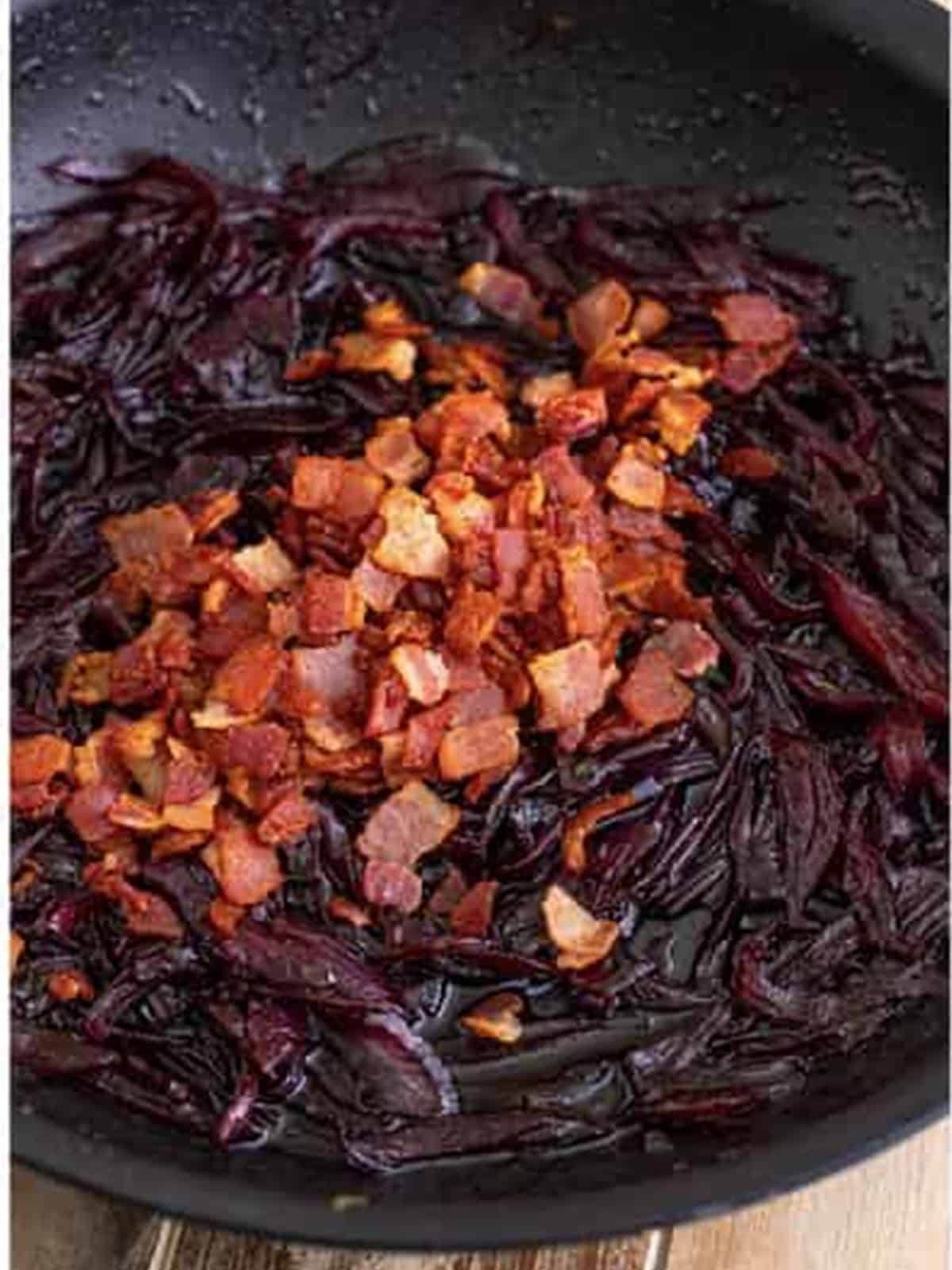 Stirring crispy cooked bacon into the red onion marmalade.