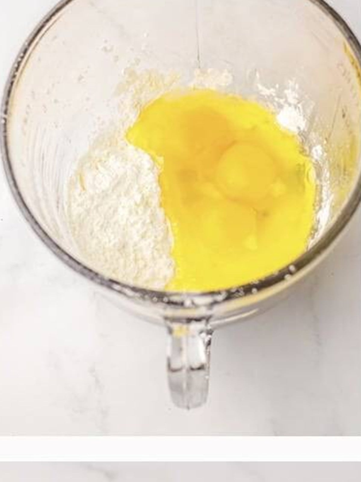 Eggs and cornstarch whisked together in a bowl for Orange Chicken.