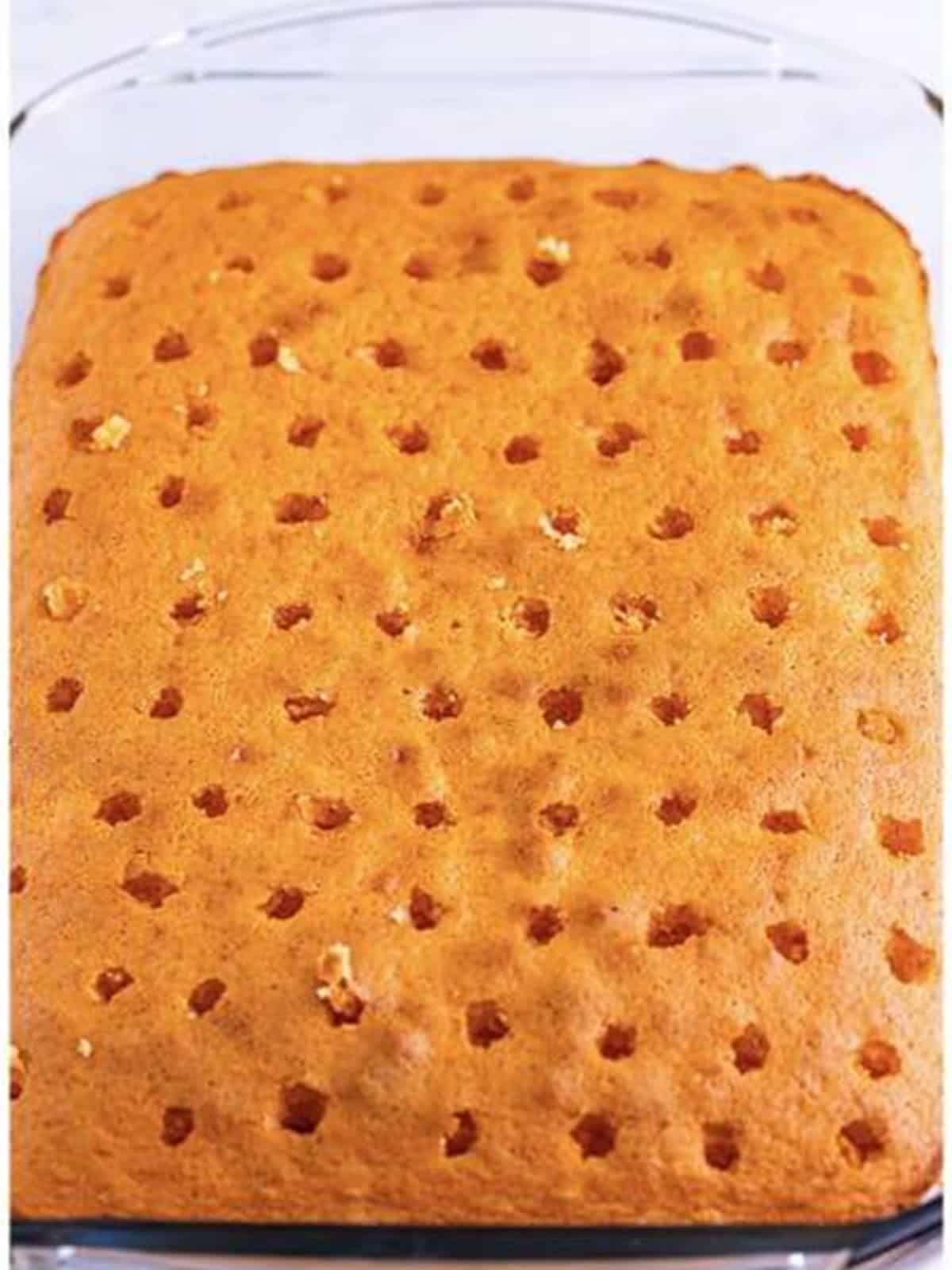 Holes poked all over the baked cake with a chopstick.