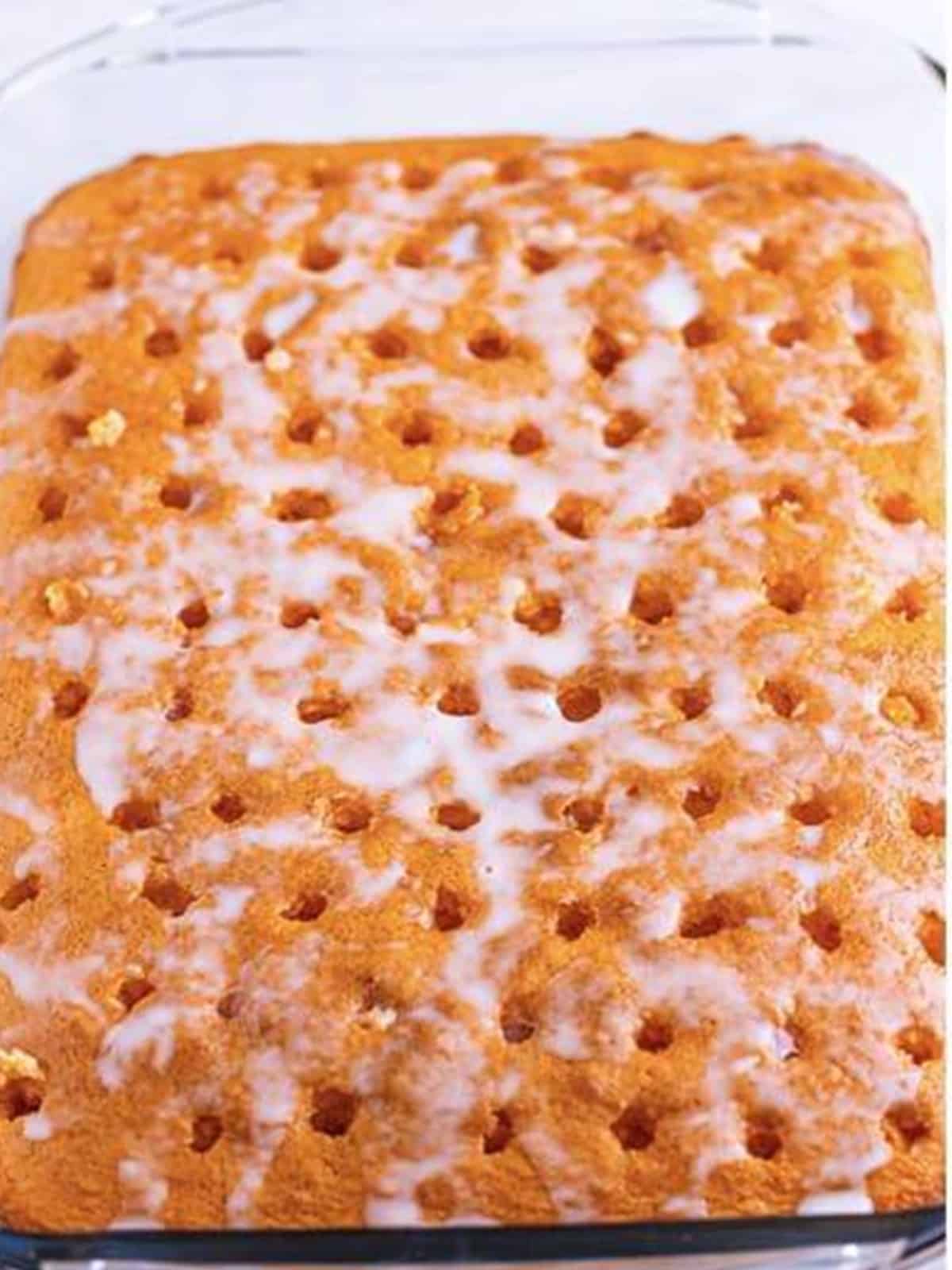 The soak absorbing into the poked orange cake as it cools.