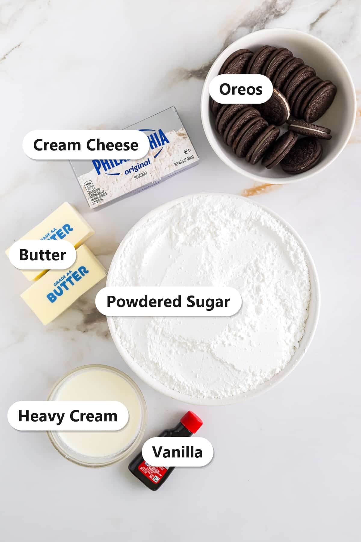 Labeled ingredients for Oreo buttercream frosting including Oreos, butter, cream cheese, powdered sugar, heavy cream, and vanilla.