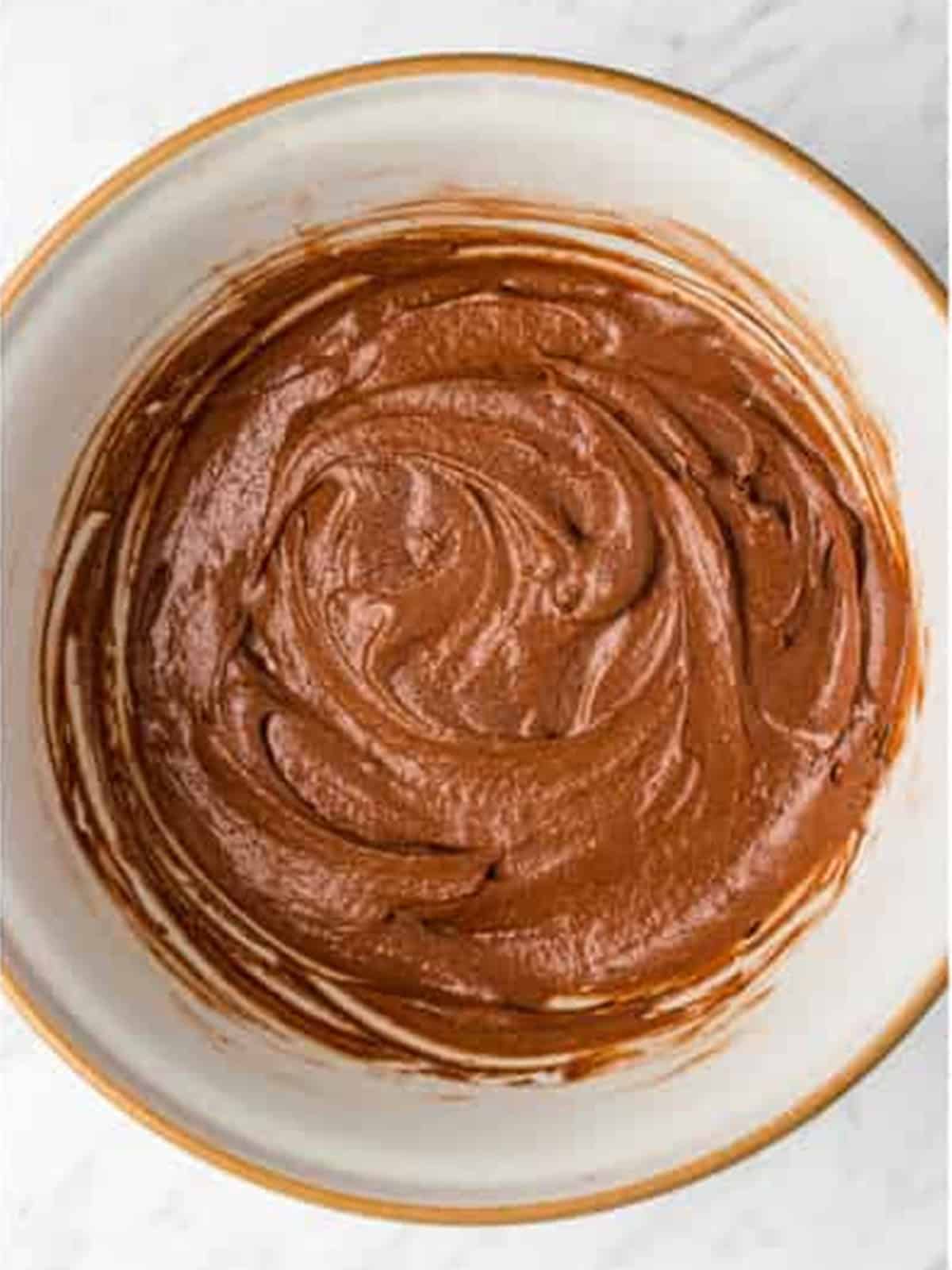 Smooth chocolate cupcake batter mixed in a bowl.