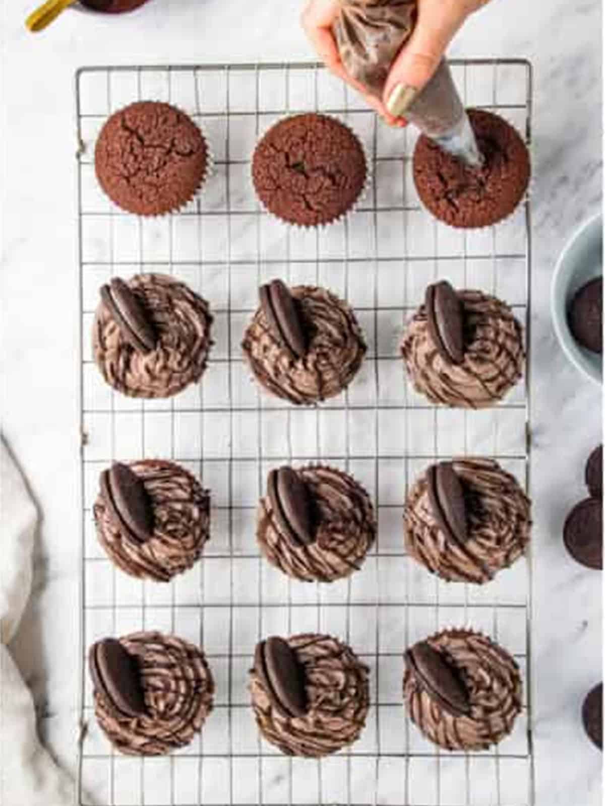 Oreo frosting piped onto cooled chocolate cupcakes and topped with an Oreo cookie.