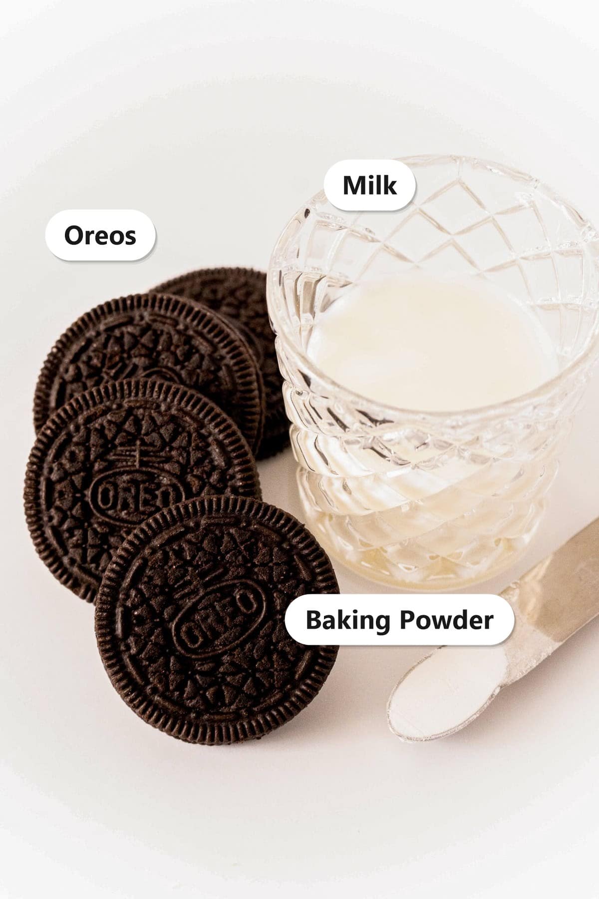 Labeled ingredients for an Oreo mug cake including Oreo cookies, milk, and baking powder.