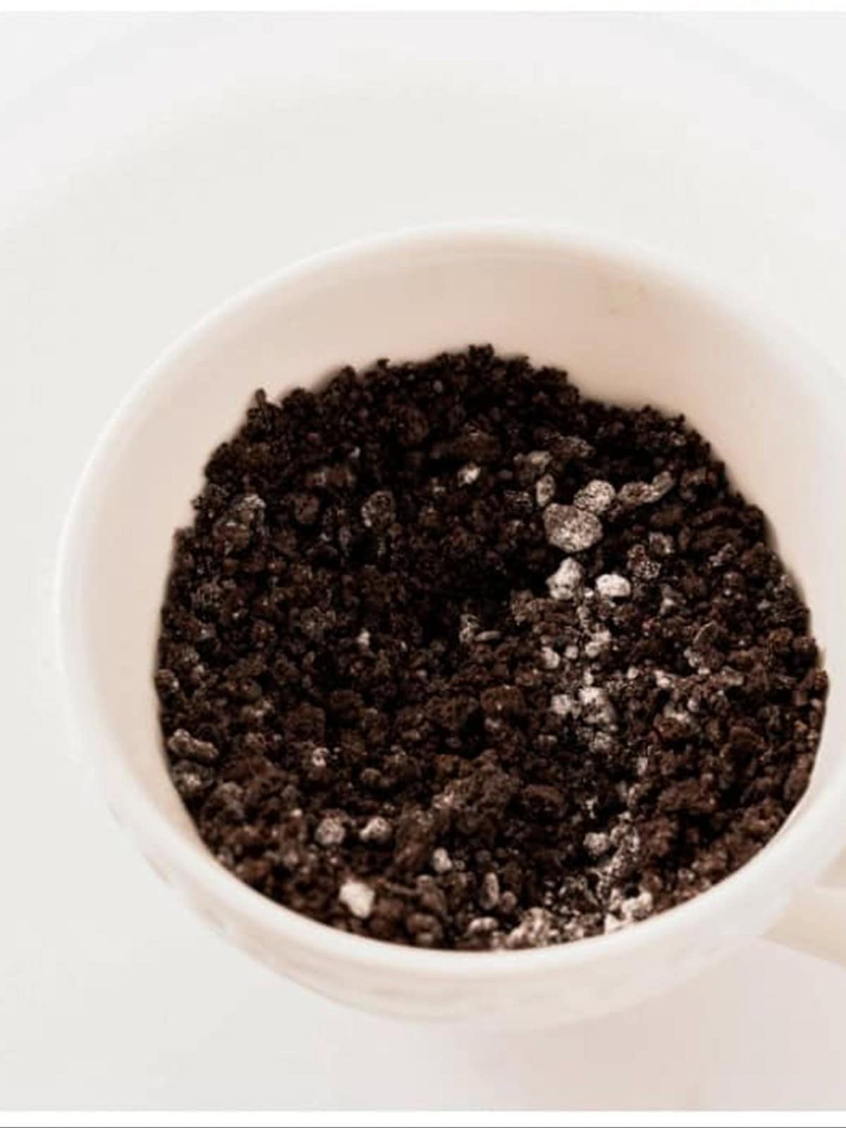 Milk and baking powder stirred into the Oreo crumbs in a mug.