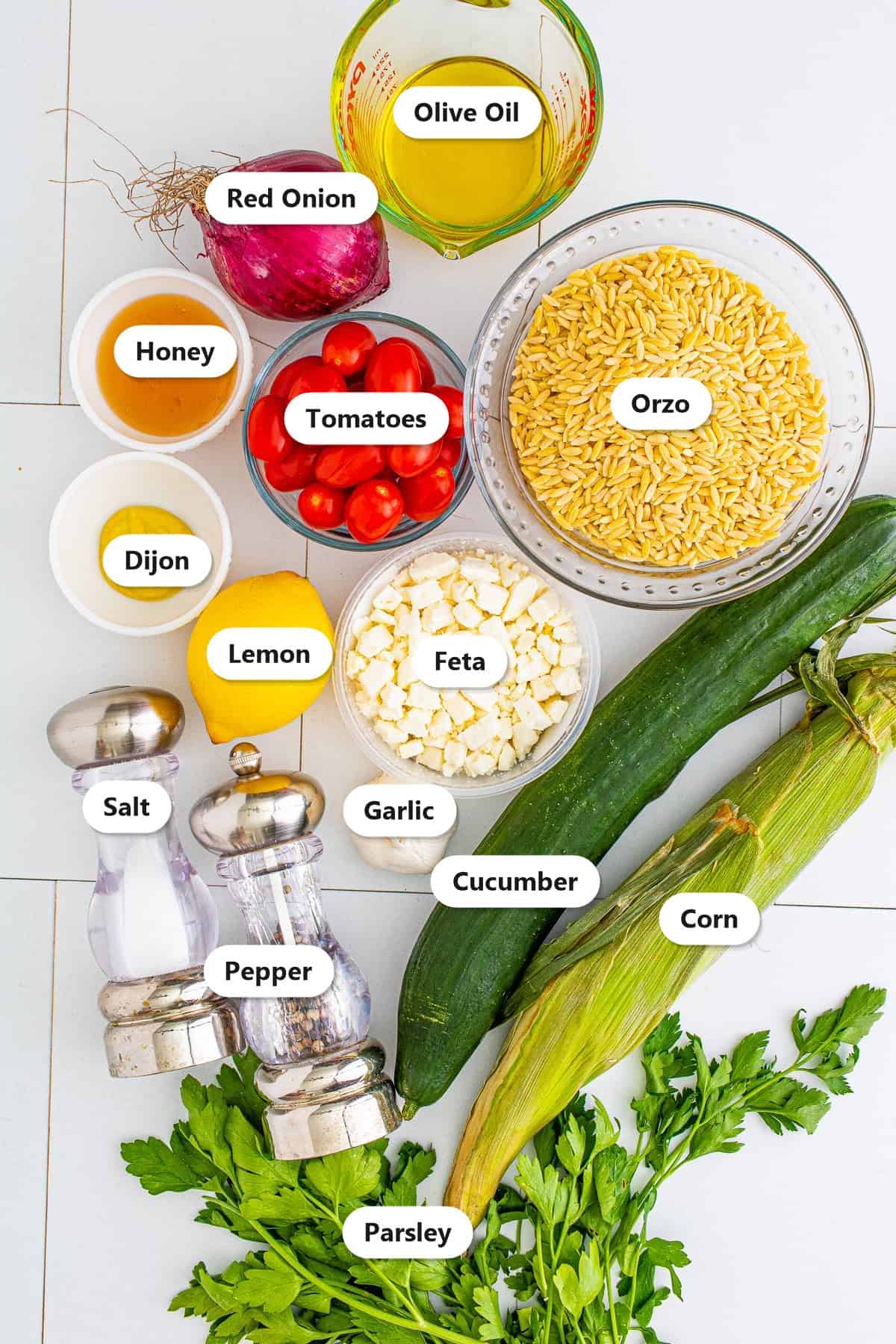 Orzo pasta salad ingredients labeled on a white board