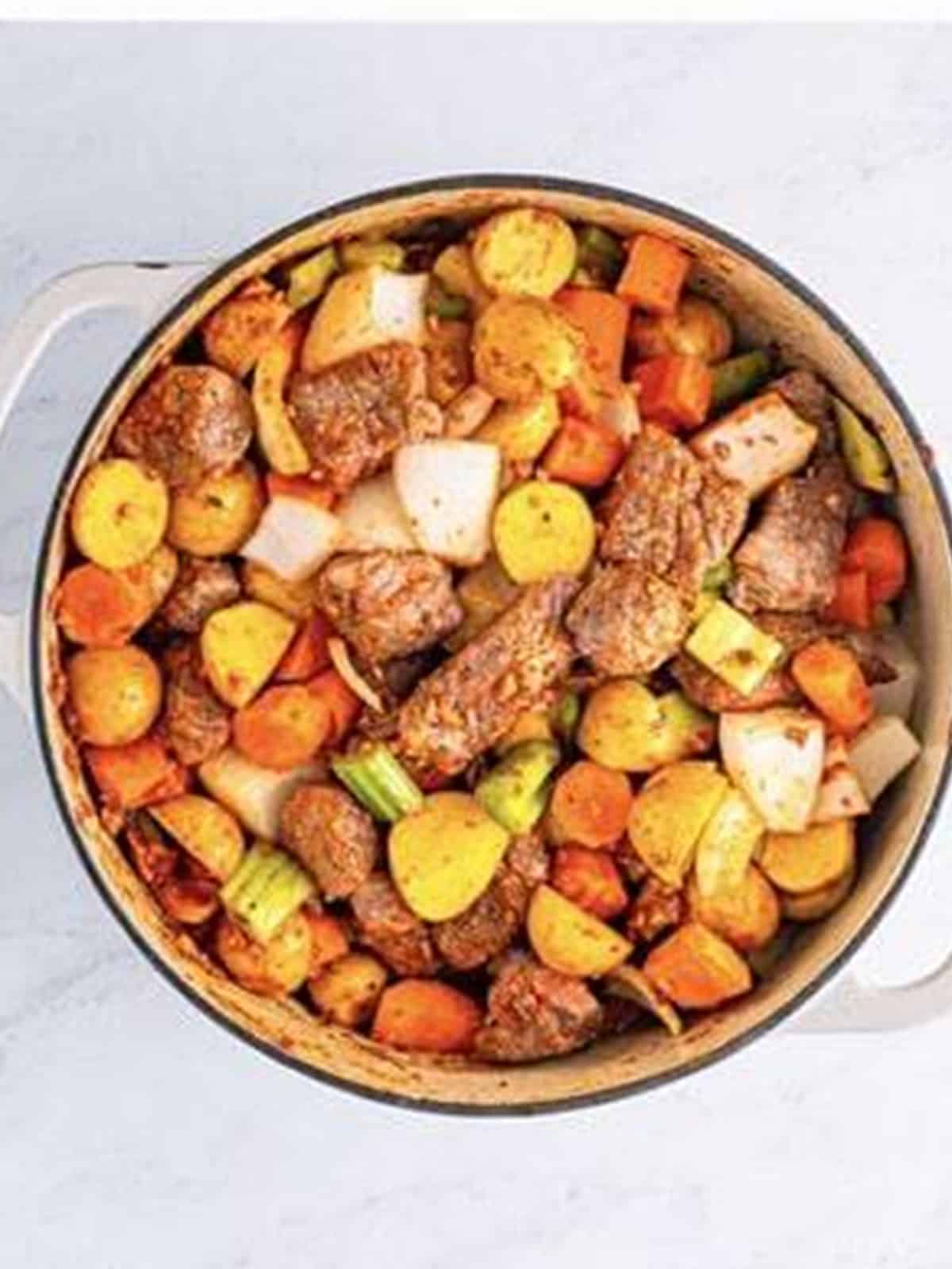 Potatoes, onion, carrots, celery, and seared beef added to the Dutch oven.