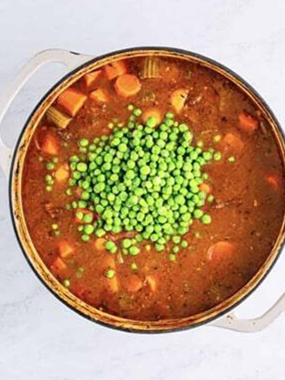 Frozen peas and butter stirred into the finished beef stew in the oven.